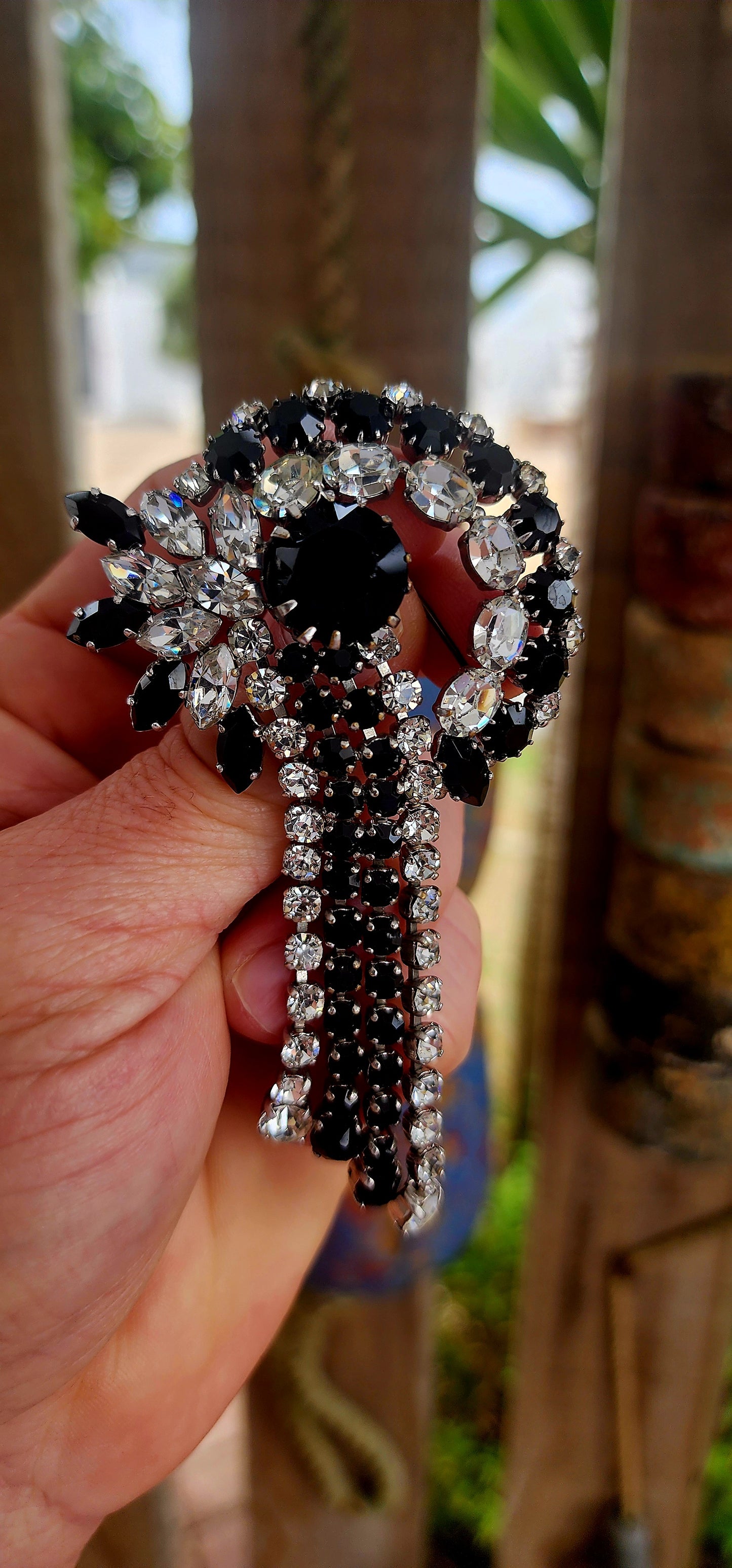 This breathtaking Art Deco era brooch is an absolute showstopper — crafted in silvertone metal and lavishly adorned with prong-set crystal rhinestones in striking shades of jet black and brilliant clear..