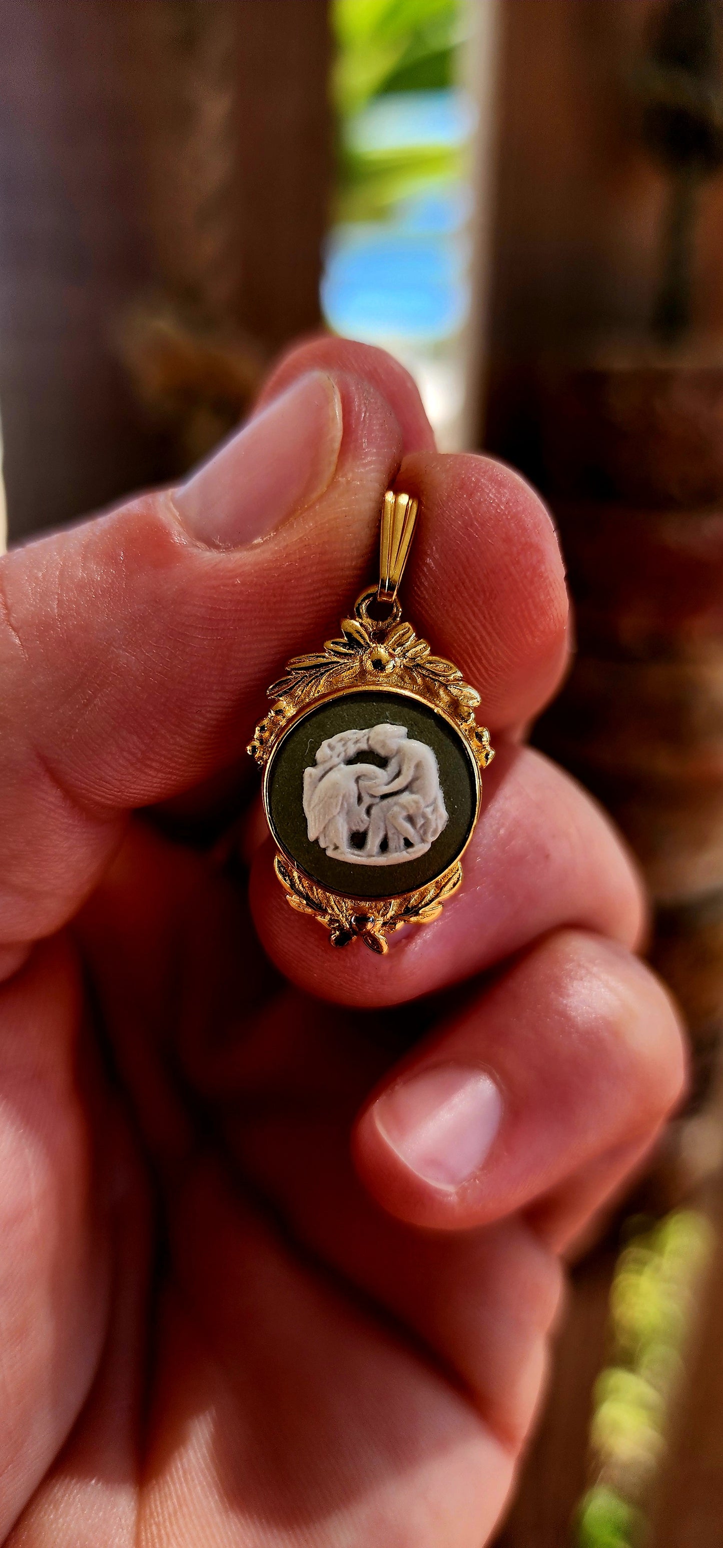 This beautiful vintage 1980s pendant features an authentic Wedgwood jasperware panel, set within an ornate yellow gold-plated frame that gives it a rich, regal presence.