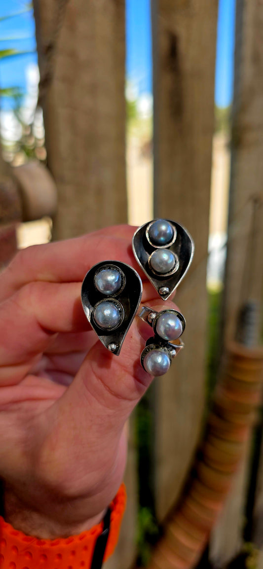 This striking circa 1970’s modernist artisan-made set consists of a sculptural Toi et Moi cross-over ring and matching clip-on earrings, all crafted in sterling silver and signed by the artist.