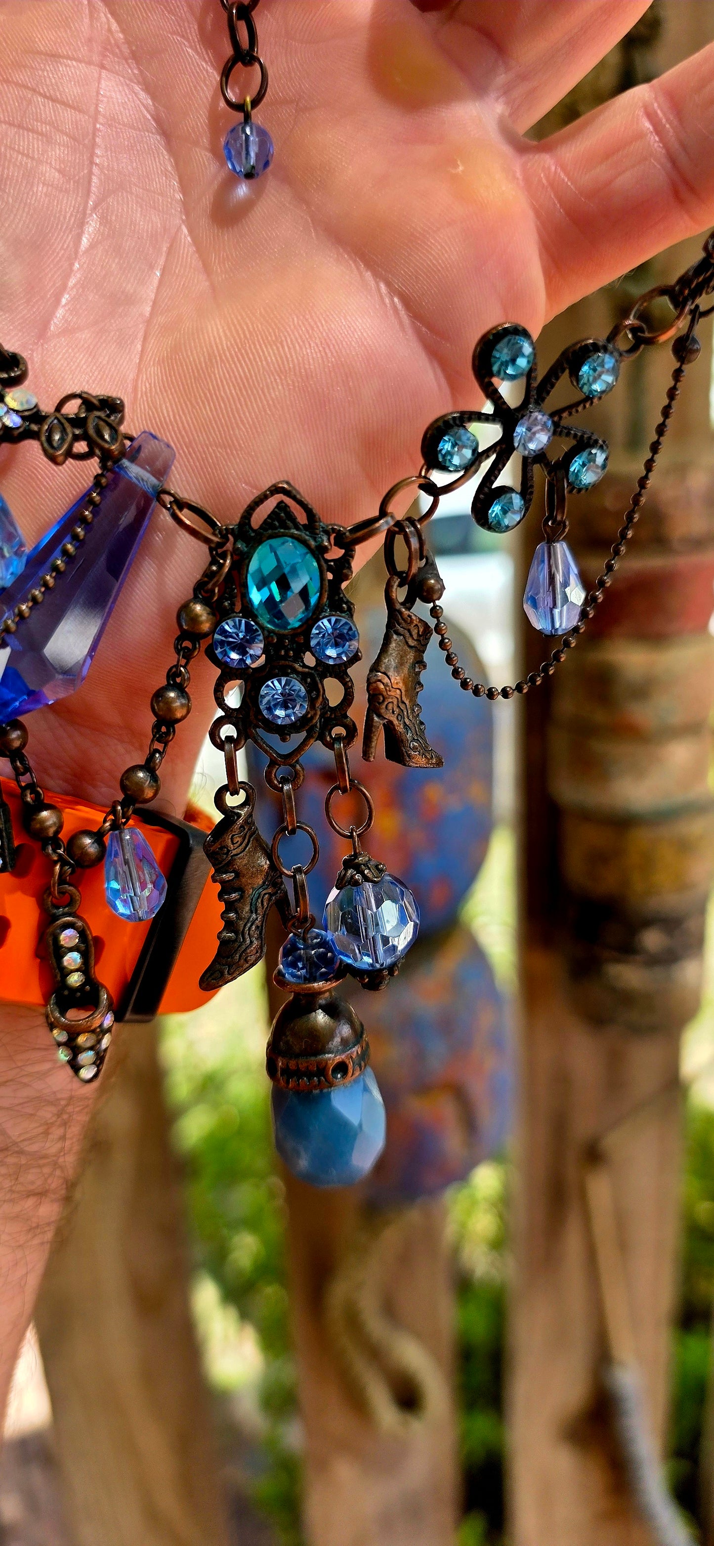 This fabulous designer costume necklace is crafted in an antique bronze-tone metal, giving it a warm, slightly vintage patina — the perfect backdrop for all those luminous blue rhinestones.