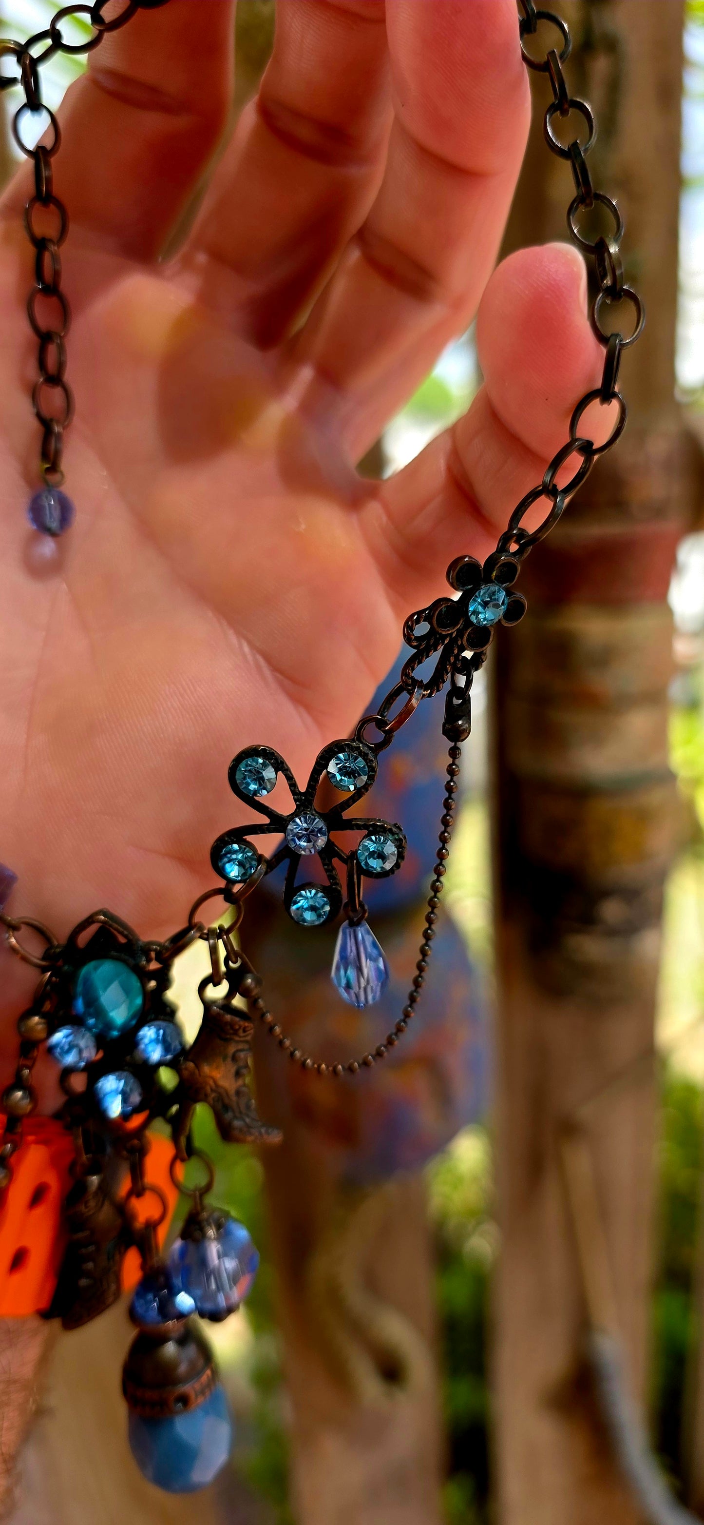 This fabulous designer costume necklace is crafted in an antique bronze-tone metal, giving it a warm, slightly vintage patina — the perfect backdrop for all those luminous blue rhinestones.