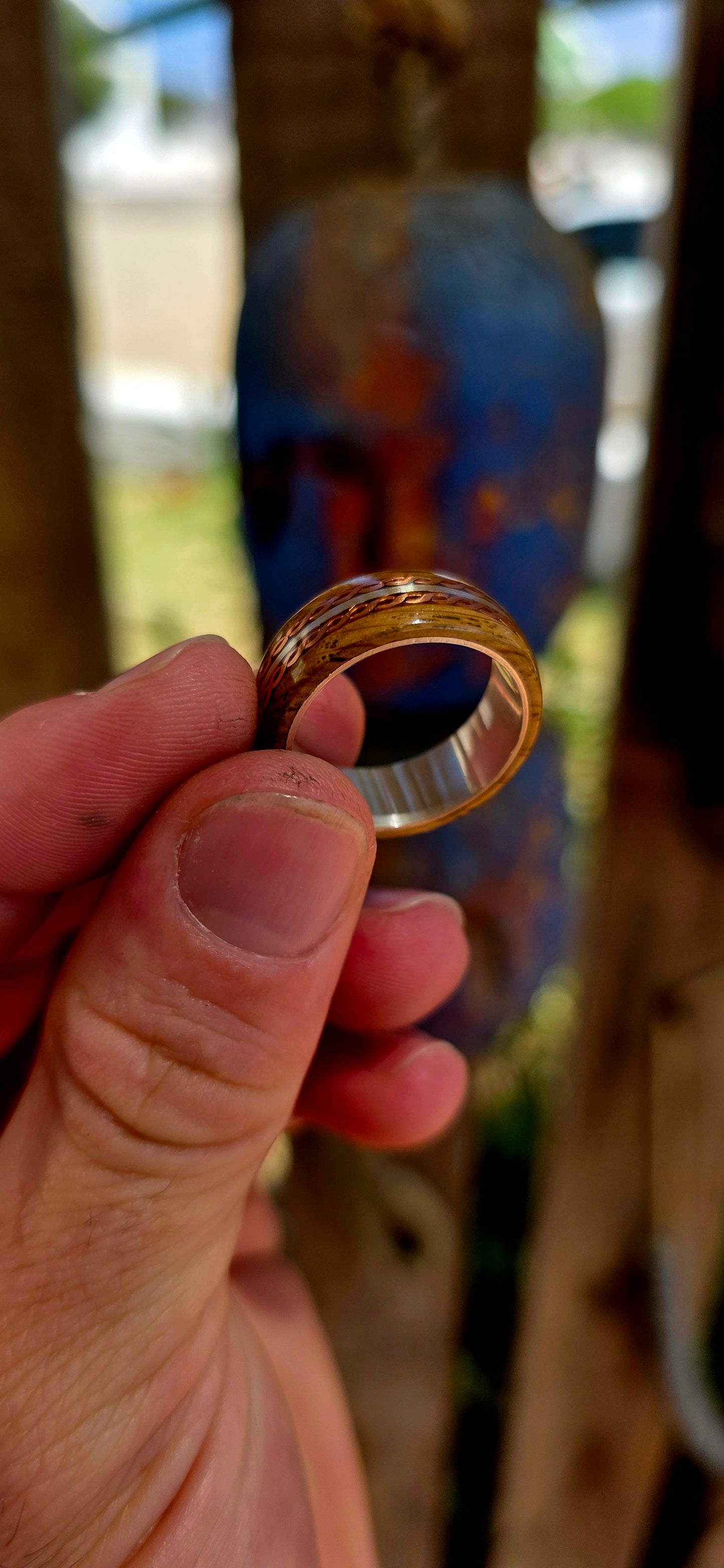 This beautifully crafted artisan ring features a solid sterling silver inner band for strength and structure, wrapped in a rich natural wood exterior that brings warmth and raw organic character.