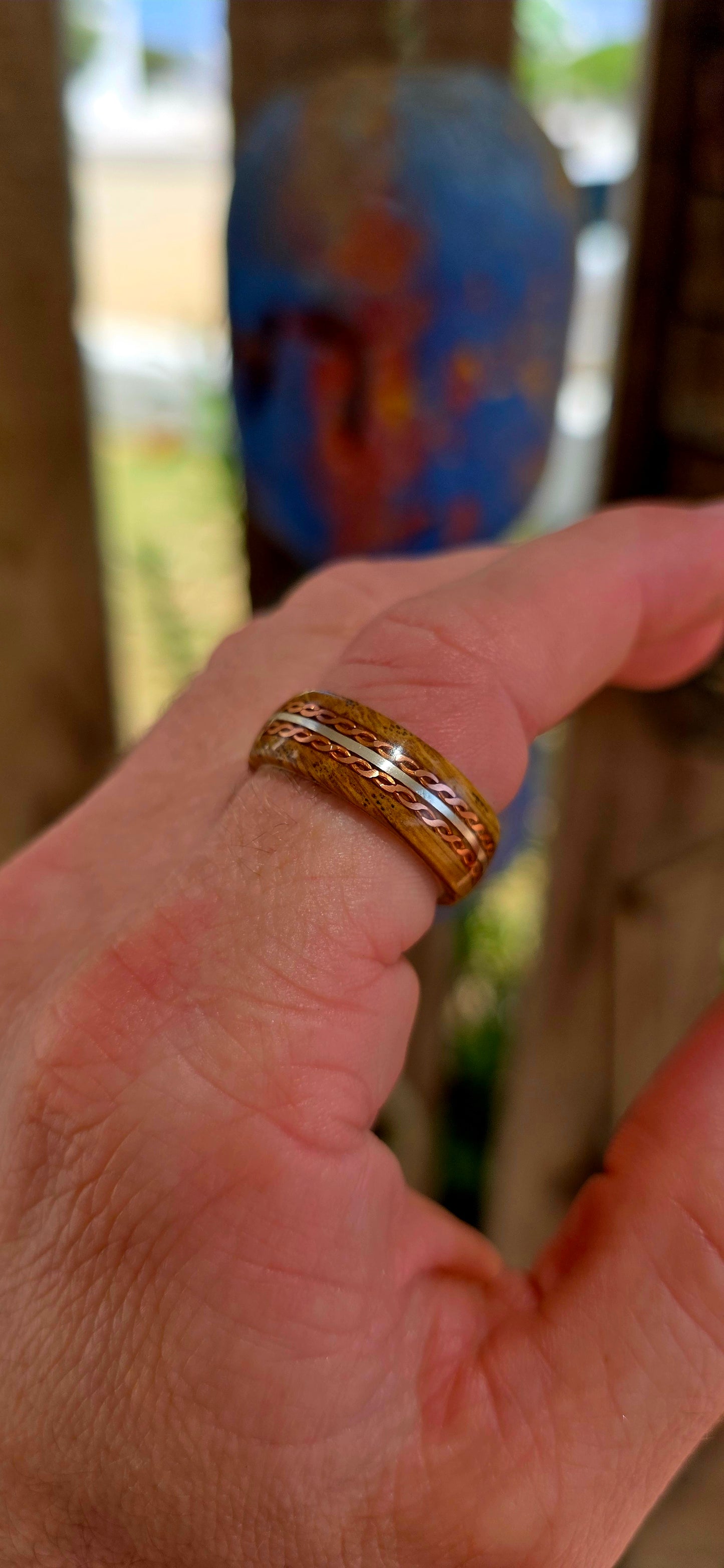 This beautifully crafted artisan ring features a solid sterling silver inner band for strength and structure, wrapped in a rich natural wood exterior that brings warmth and raw organic character.