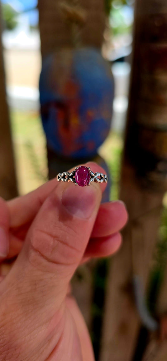 This beautiful sterling silver solitaire-style ring features a glowing oval-cut ruby cabochon, prong-set proudly at the centre