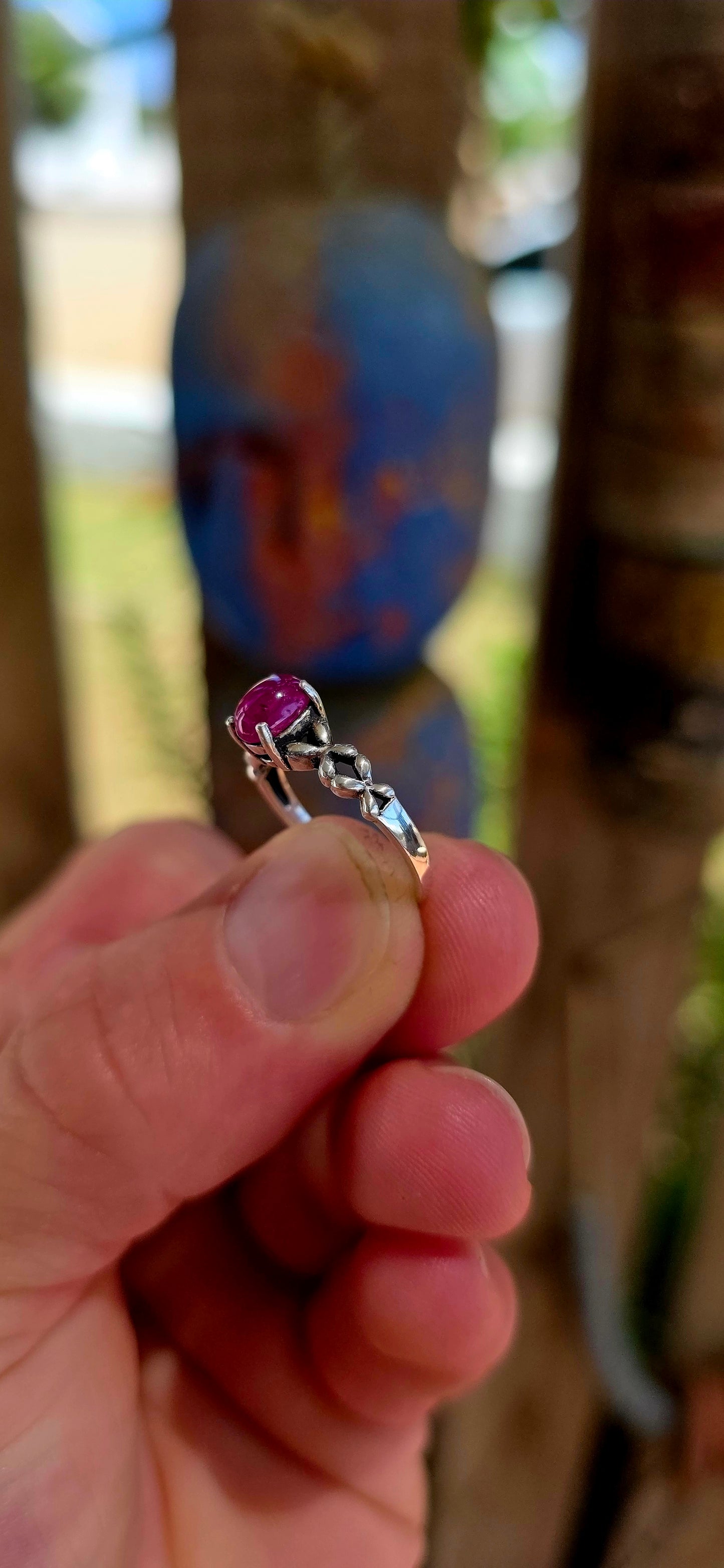 This beautiful sterling silver solitaire-style ring features a glowing oval-cut ruby cabochon, prong-set proudly at the centre