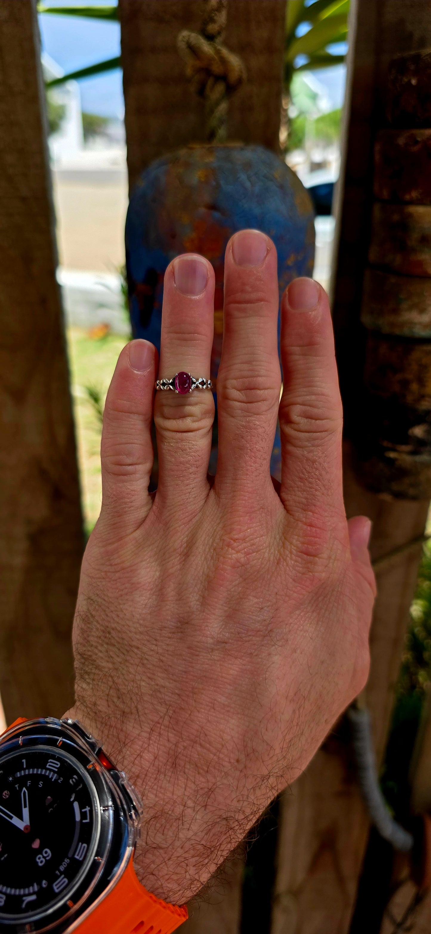 This beautiful sterling silver solitaire-style ring features a glowing oval-cut ruby cabochon, prong-set proudly at the centre
