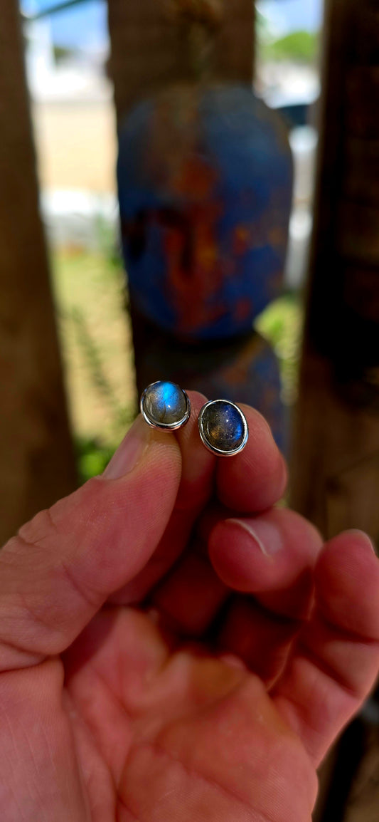This beautiful unisex pair of sterling silver stud earrings features glowing oval-cut labradorite cabochons, securely tube-set in sleek sterling silver bezels.