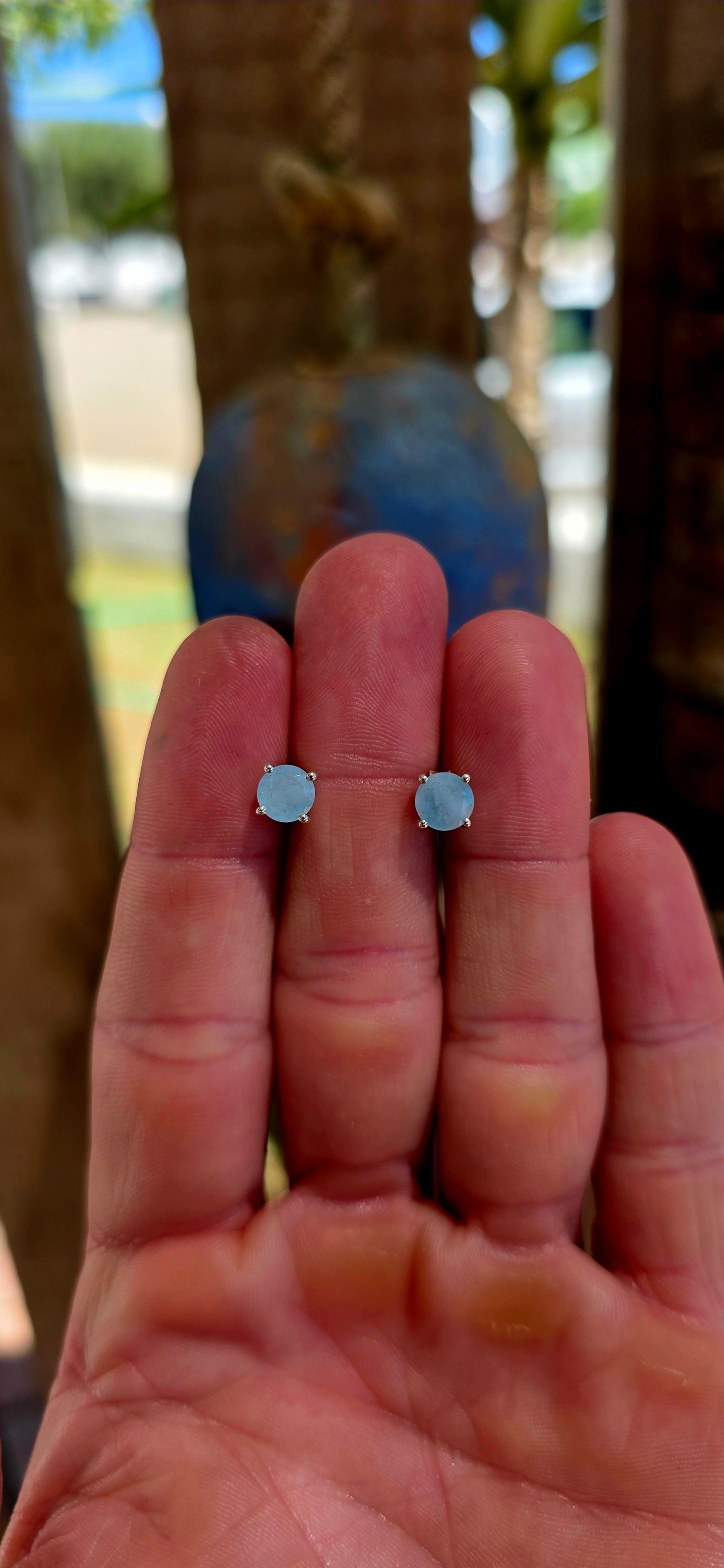 This striking pair of unisex sterling silver stud earrings features round faceted aquamarine gemstones in a soft milky / opaque tone — giving them a dreamy, sea-glass quality rather than a fully transparent sparkle.