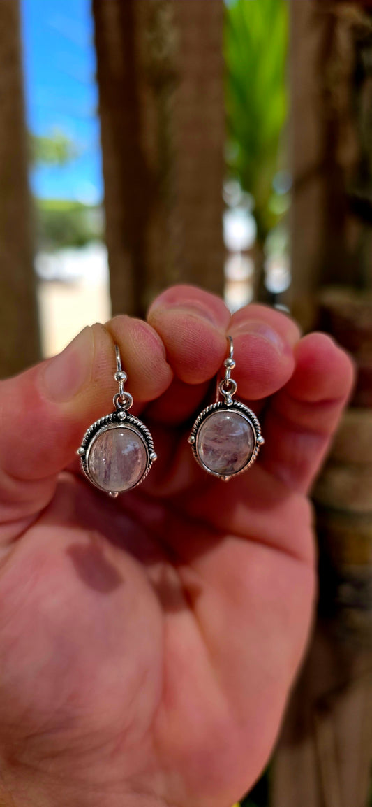 This beautiful pair of bohemian dangle earrings is crafted in solid sterling silver and set with glowing oval moonstone cabochons.