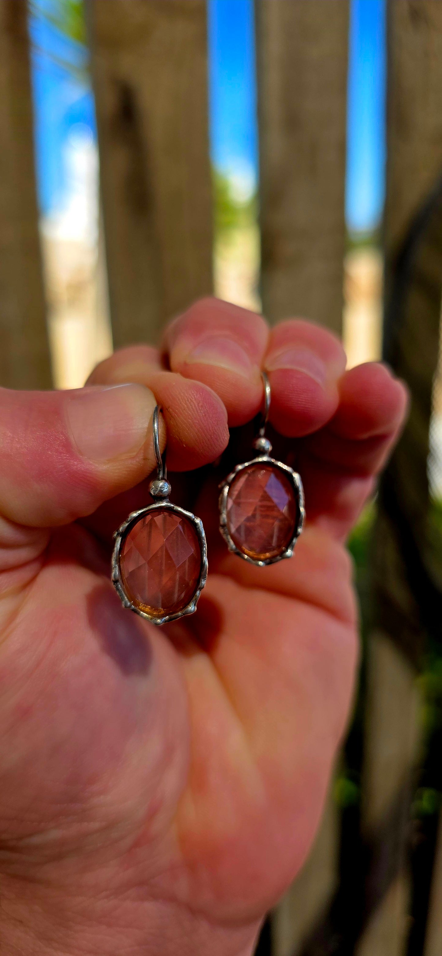 These beautiful artisan-made designer earrings are crafted in sterling silver and feature luminous faceted oval-cut strawberry quartz gemstones in a warm, soft rose hue.
