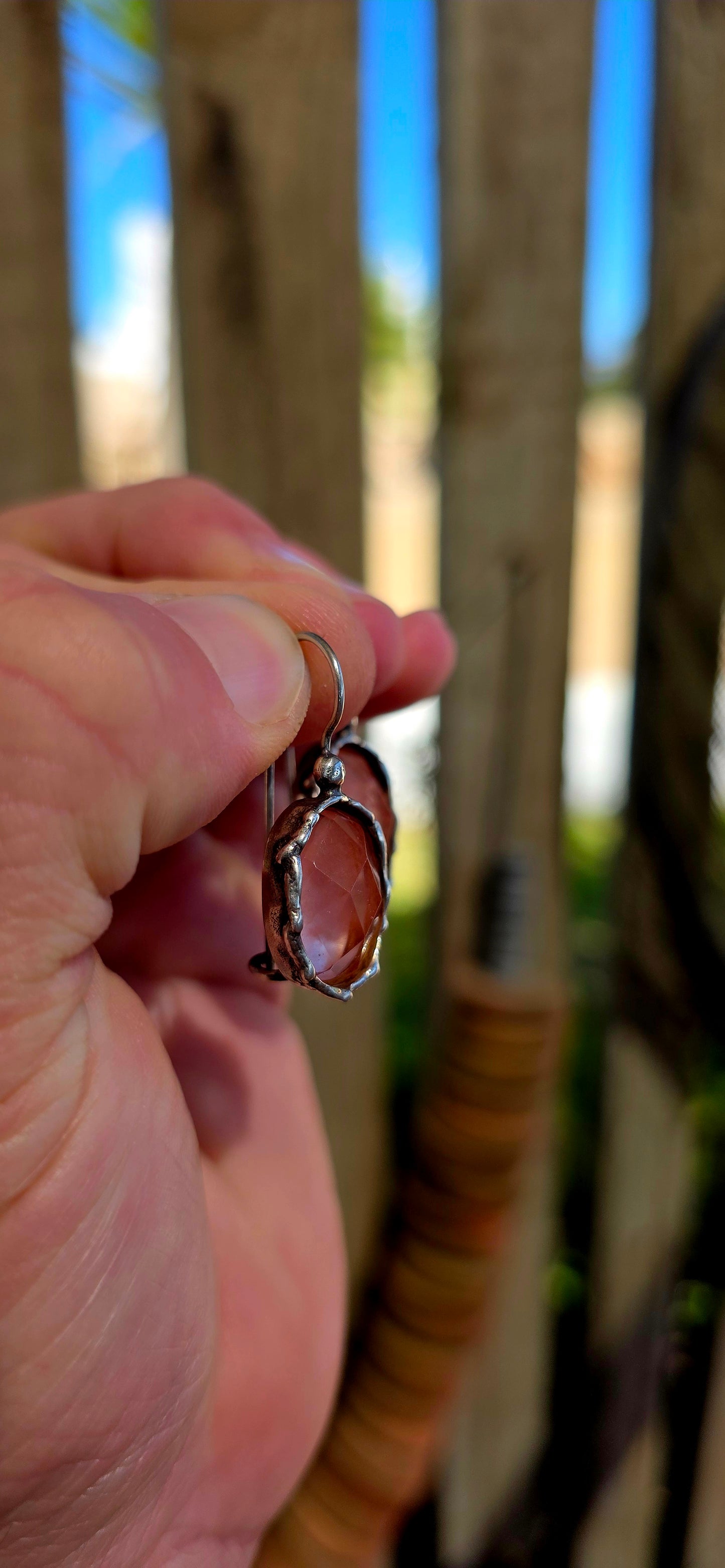 These beautiful artisan-made designer earrings are crafted in sterling silver and feature luminous faceted oval-cut strawberry quartz gemstones in a warm, soft rose hue.