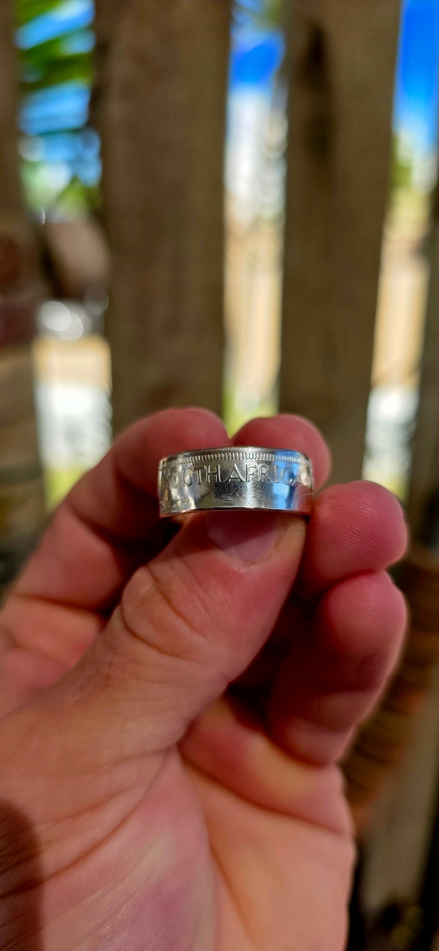 This fantastic artisan-made coin ring has been crafted from an authentic South African 2½ Shilling coin dated 1956, struck in .500 silver during the Union of South Africa era.