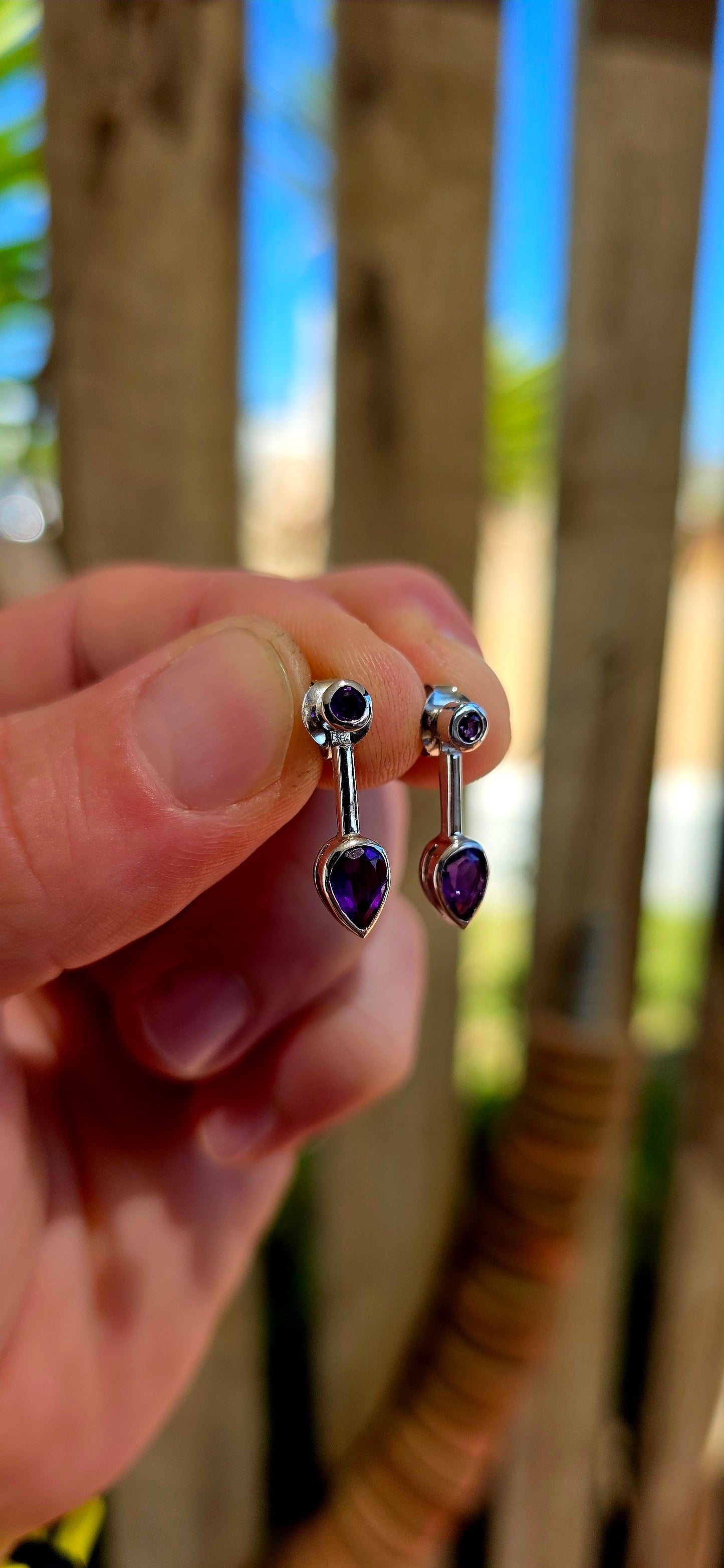 This beautiful pair of modernist-style drop earrings is crafted in solid sterling silver, featuring a sleek geometric design that perfectly showcases the rich colour of amethyst gemstones.