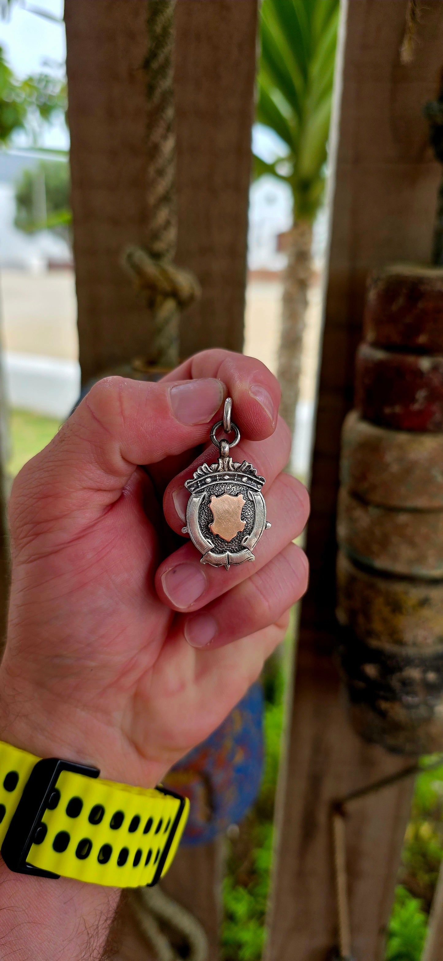 This beautiful antique shield fob pendant is crafted in hallmarked sterling silver, featuring a striking 9ct rose gold shield cartouche at its centre.