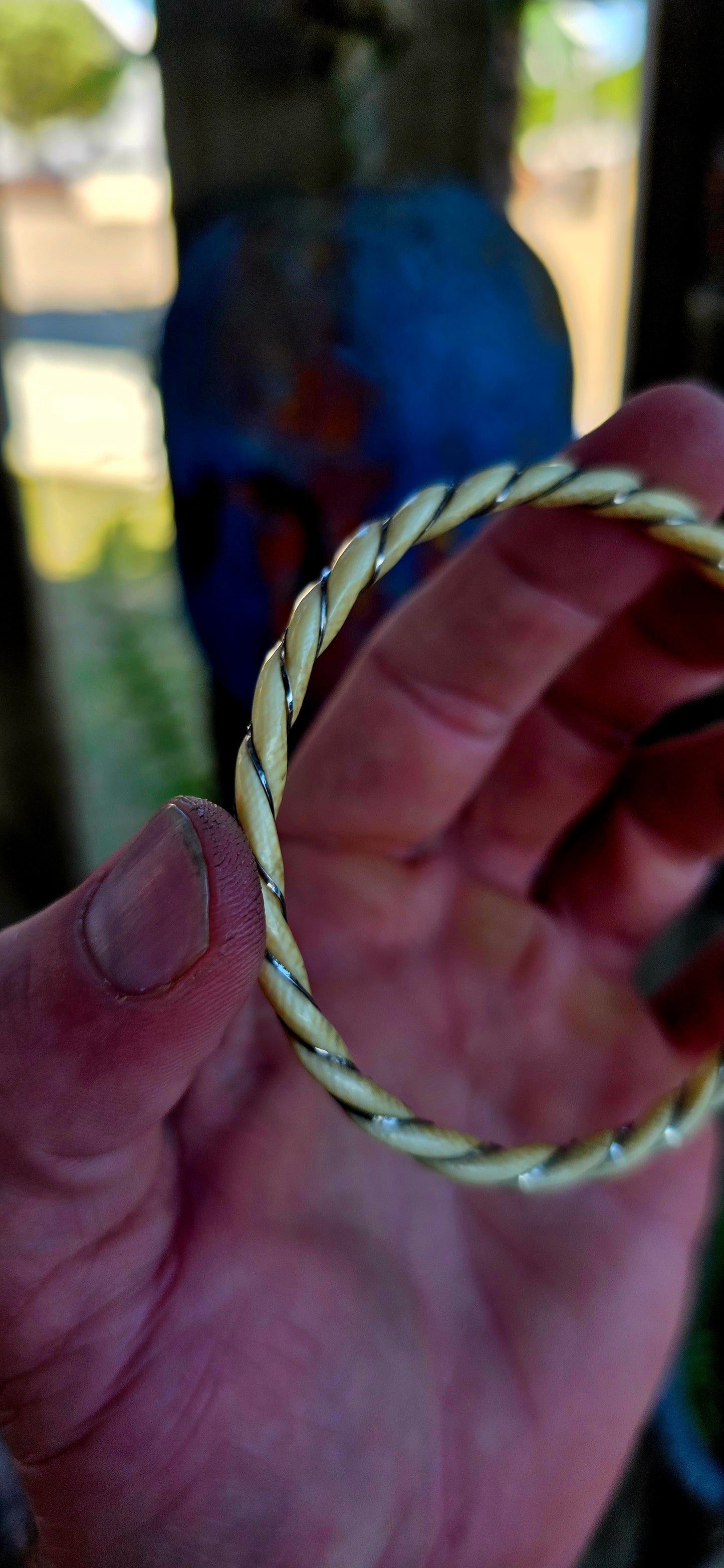 A beautiful antique hand-carved ivory bangle, crafted in a graceful twisted rope / swirl pattern and delicately wrapped with fine sterling silver wire that spirals along the entire circumference of the bracelet.
