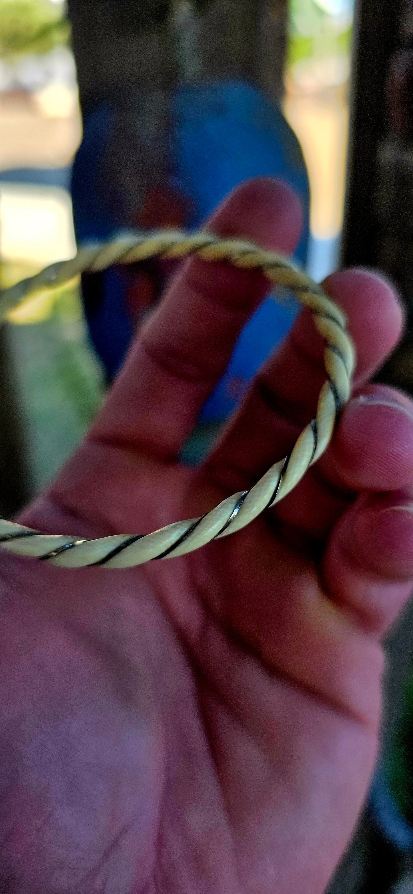 A beautiful antique hand-carved ivory bangle, crafted in a graceful twisted rope / swirl pattern and delicately wrapped with fine sterling silver wire that spirals along the entire circumference of the bracelet.