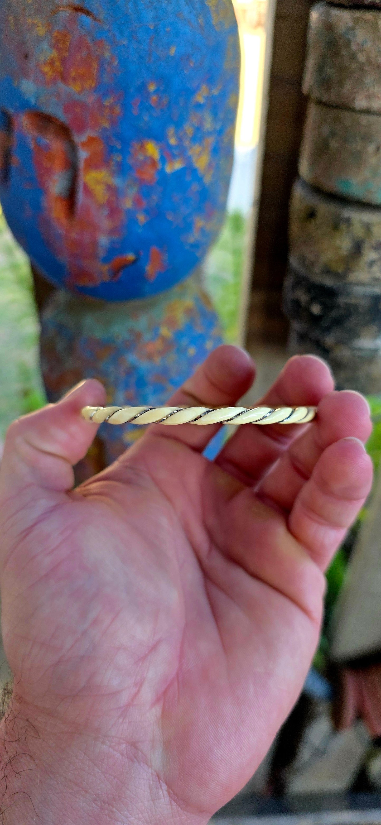 A beautiful antique hand-carved ivory bangle, crafted in a graceful twisted rope / swirl pattern and delicately wrapped with fine sterling silver wire that spirals along the entire circumference of the bracelet.
