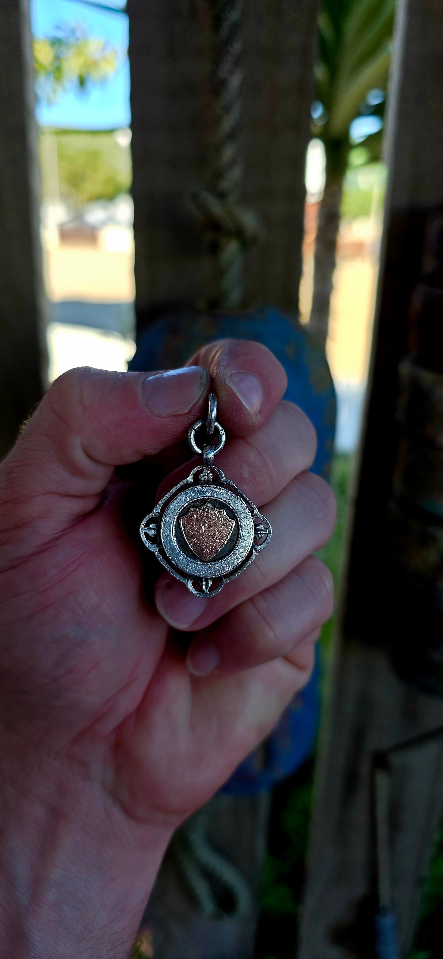 A beautiful antique hallmarked fob shield pendant, crafted in sterling silver and decorated with a raised 9ct rose gold shield cartouche, creating a striking and elegant two-tone contrast.