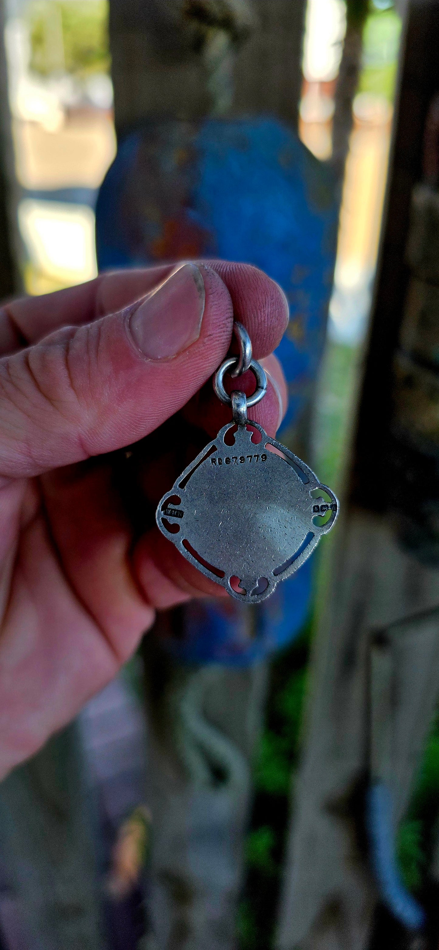 A beautiful antique hallmarked fob shield pendant, crafted in sterling silver and decorated with a raised 9ct rose gold shield cartouche, creating a striking and elegant two-tone contrast.