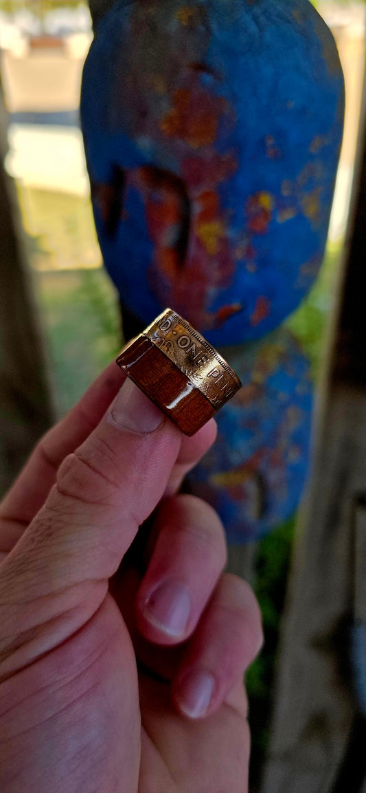 This striking extra-wide artisan statement ring combines natural materials with historic coinage, resulting in a piece that feels earthy and adventurous — the kind of ring that looks like it belongs on a treasure hunter’s hand.