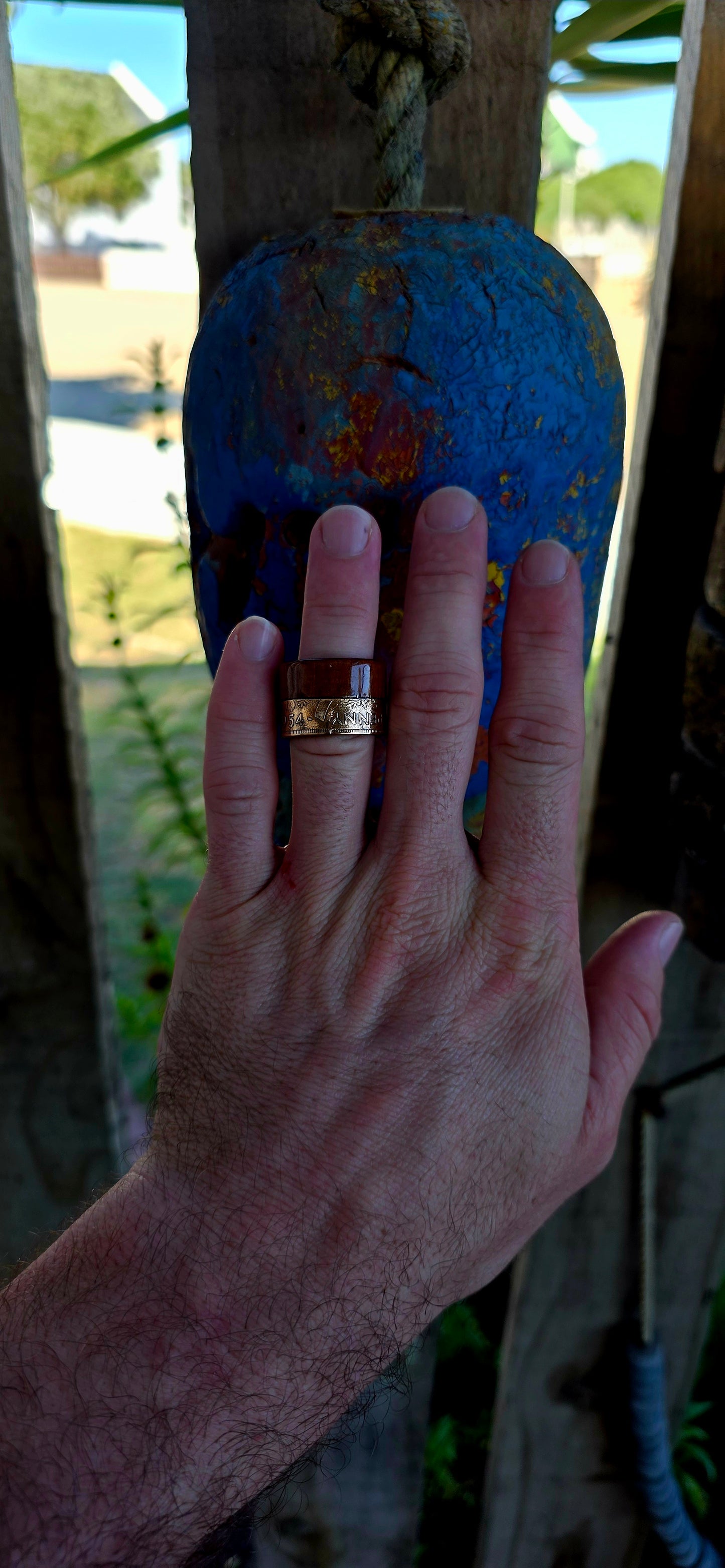 This striking extra-wide artisan statement ring combines natural materials with historic coinage, resulting in a piece that feels earthy and adventurous — the kind of ring that looks like it belongs on a treasure hunter’s hand.