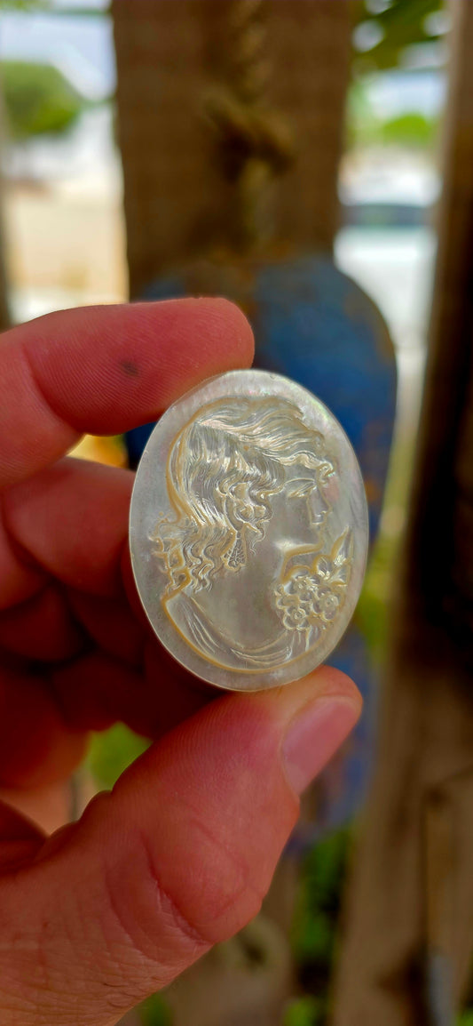 This beautiful vintage cameo is hand carved from luminous mother of pearl, displaying the soft iridescent glow that makes this material so prized in cameo carving.
