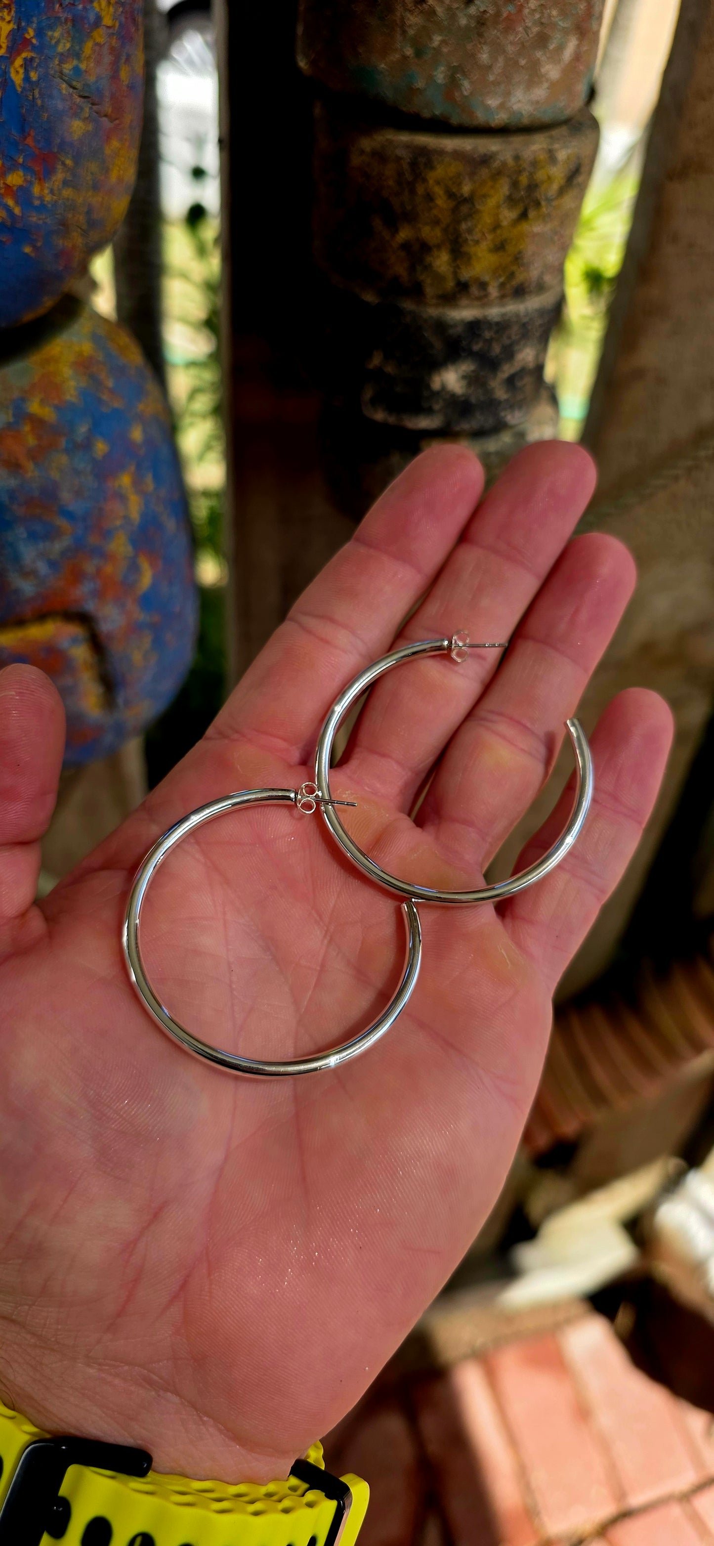 These are proper statement hoops — a generously sized pair crafted in sterling silver, designed in a classic round tubular (hollow) form that gives you that big, bold look without the heavy weight.