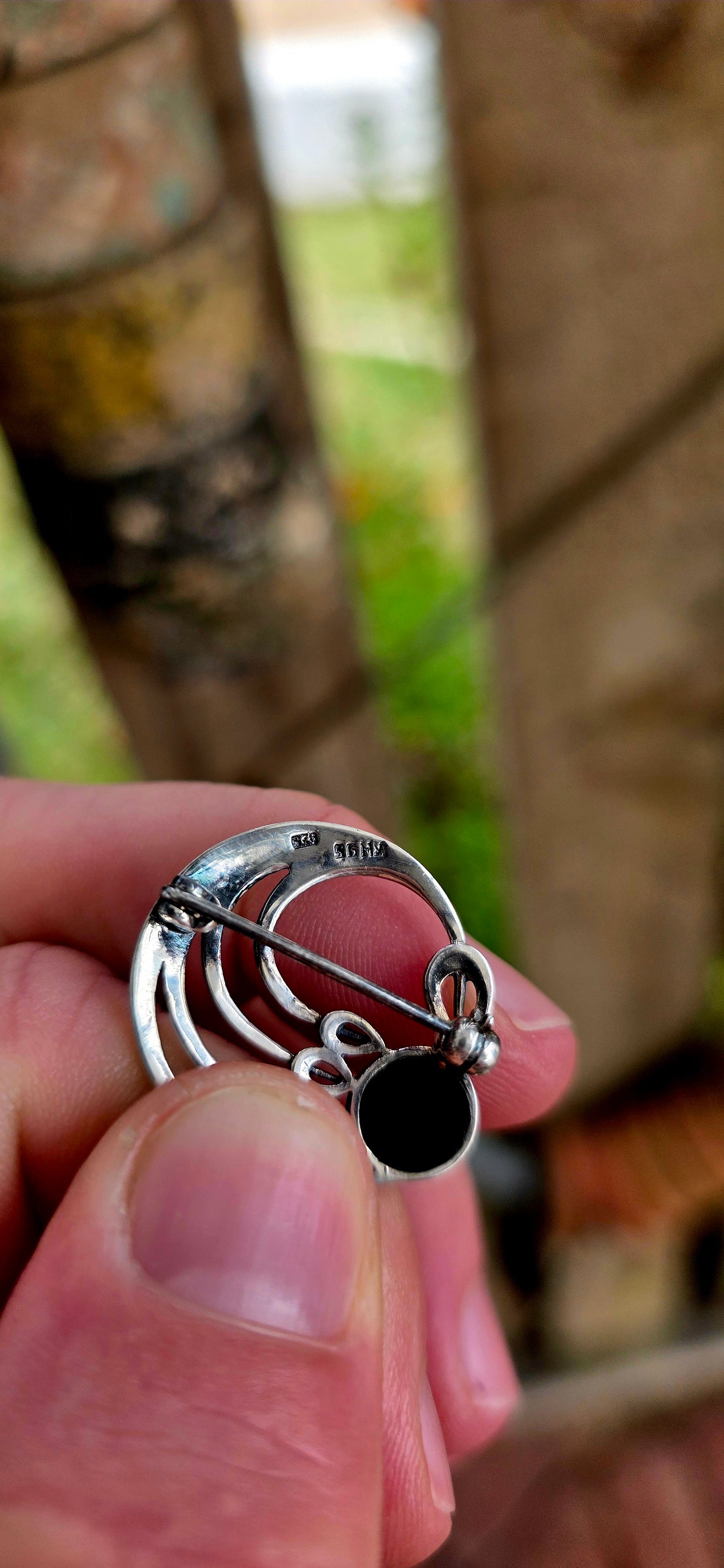 A pretty and petite vintage designer brooch, crafted in solid sterling silver and set with black onyx, created by renowned British jewellery house Kit Heath circa 1995.