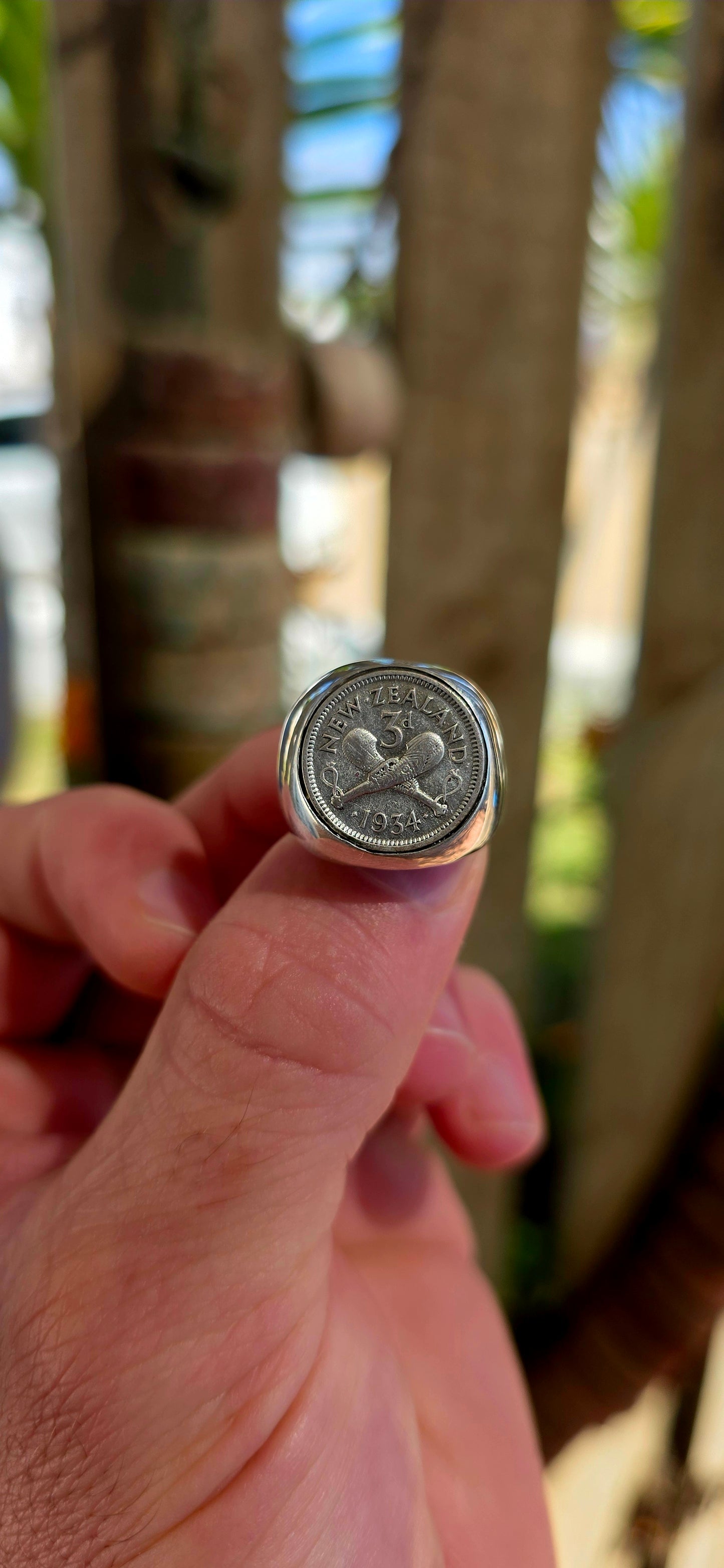 A chunky, solid sterling silver artisan-made signet ring, set with an authentic 1934 New Zealand coin featuring the classic crossed clubs motif.