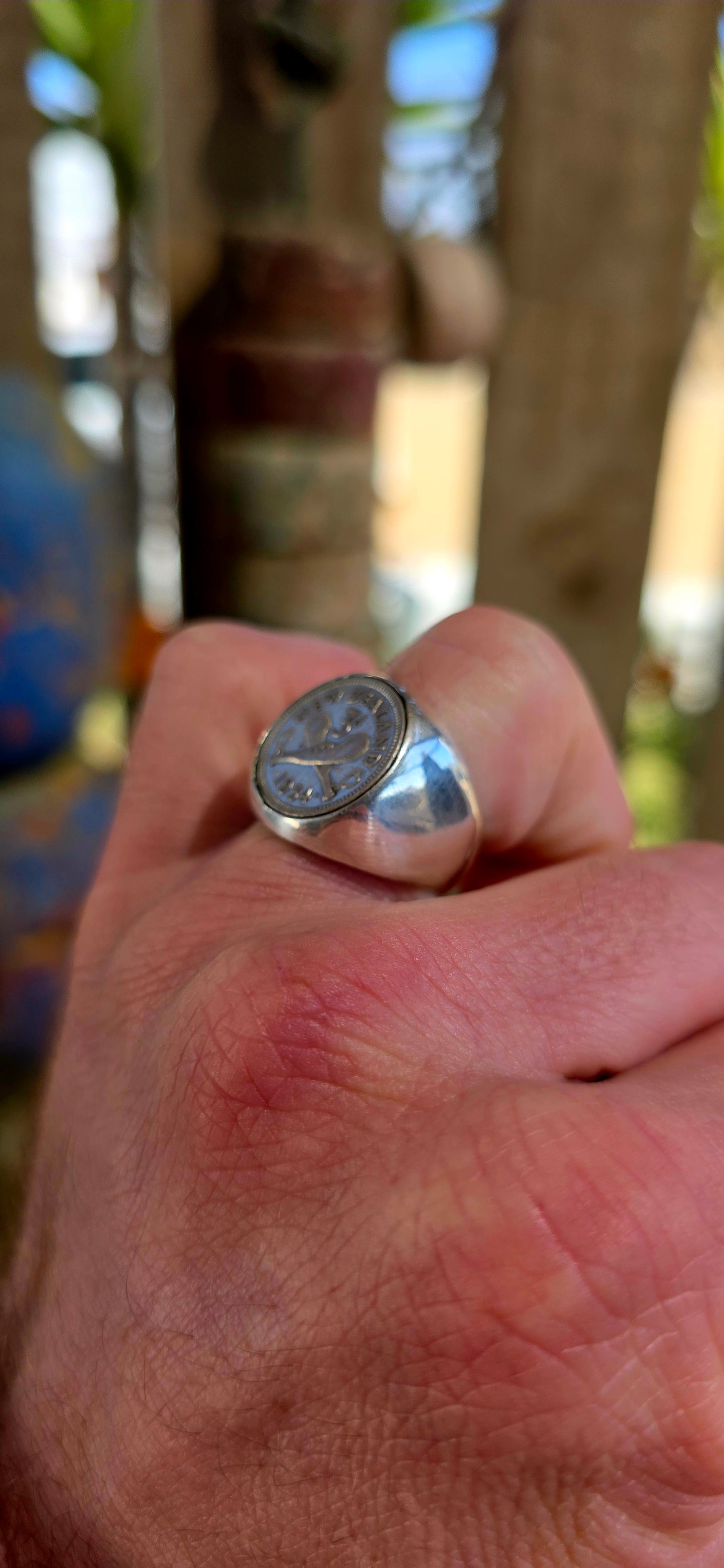 A chunky, solid sterling silver artisan-made signet ring, set with an authentic 1934 New Zealand coin featuring the classic crossed clubs motif.