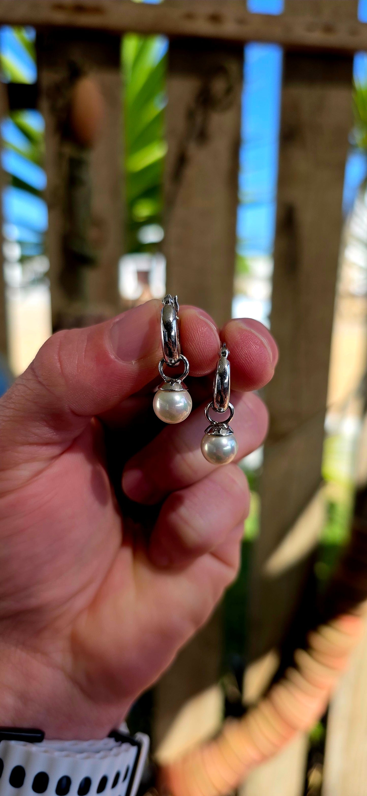 A beautiful pair of sterling silver huggie/hoop earrings, each fitted with removable shell pearl dangles — giving you two looks in one