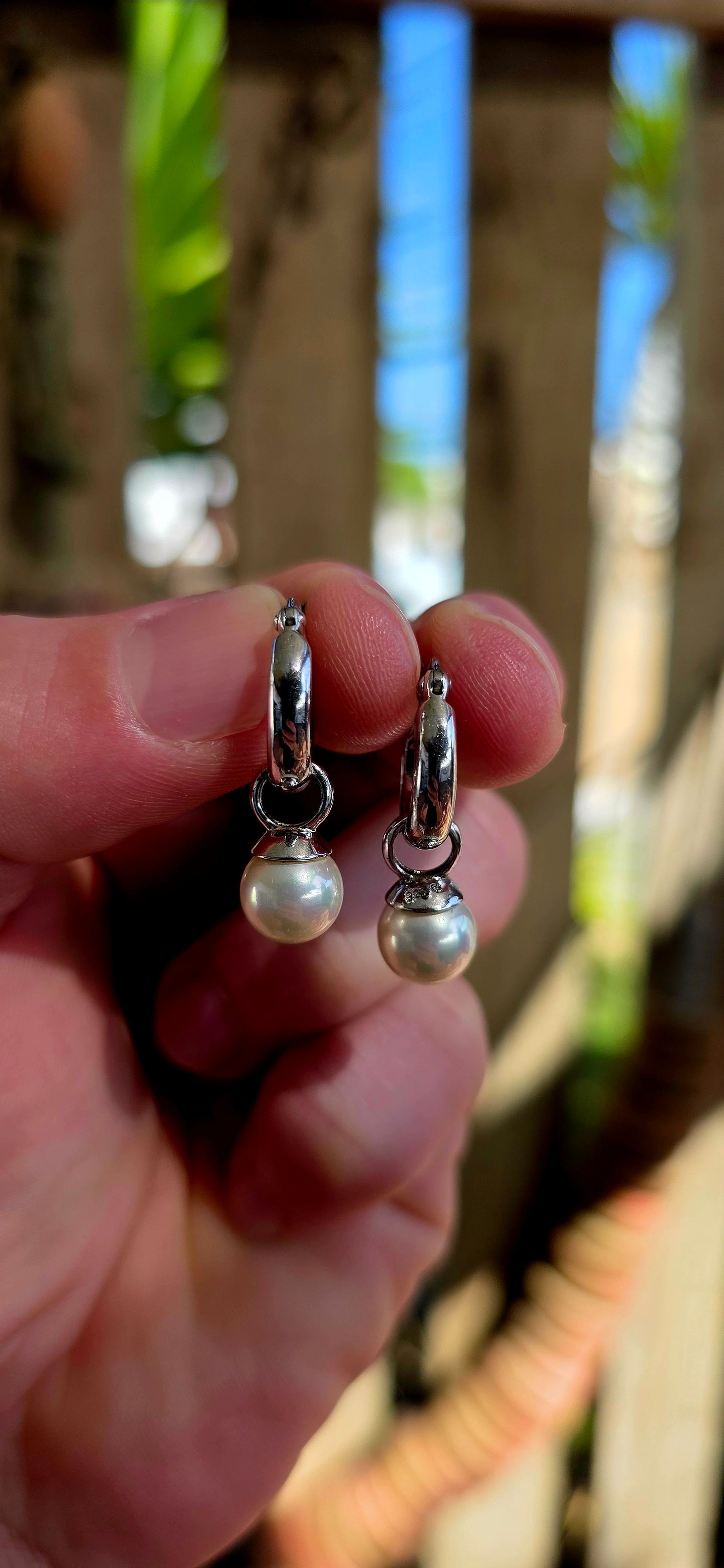 A beautiful pair of sterling silver huggie/hoop earrings, each fitted with removable shell pearl dangles — giving you two looks in one