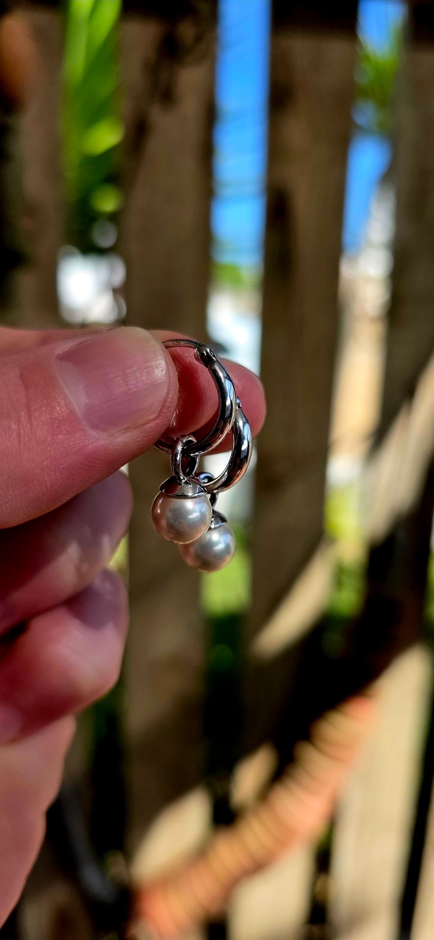 A beautiful pair of sterling silver huggie/hoop earrings, each fitted with removable shell pearl dangles — giving you two looks in one