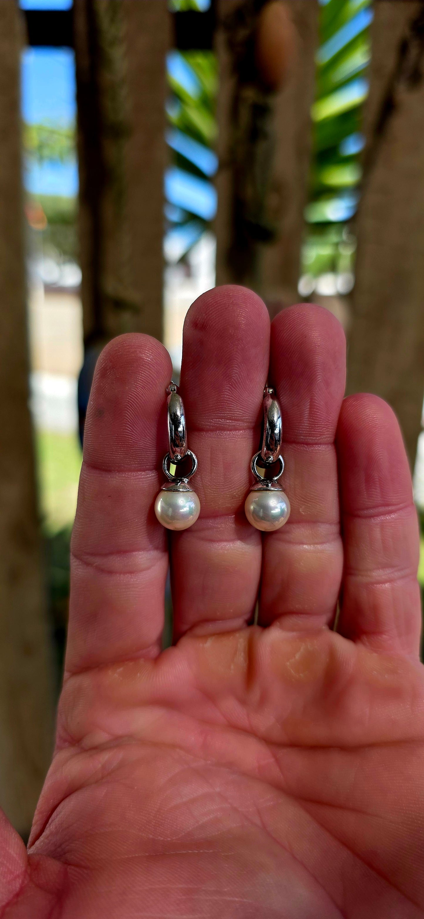 A beautiful pair of sterling silver huggie/hoop earrings, each fitted with removable shell pearl dangles — giving you two looks in one