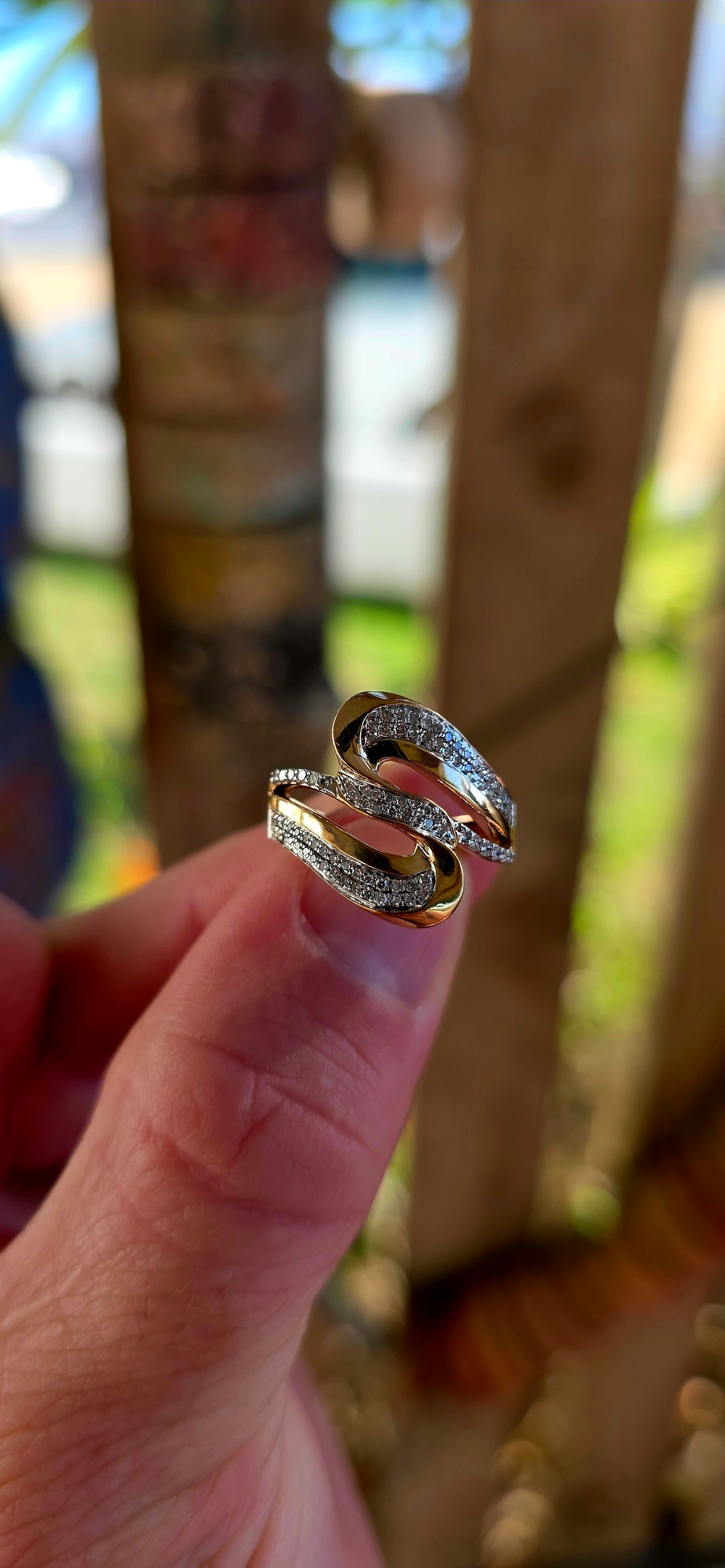 A striking modernist 9ct yellow gold dress ring, crafted in a bold passover / bypass (“toi et moi”) design, where two flowing forms curve gracefully around one another — symbolising two souls meeting and intertwining.
