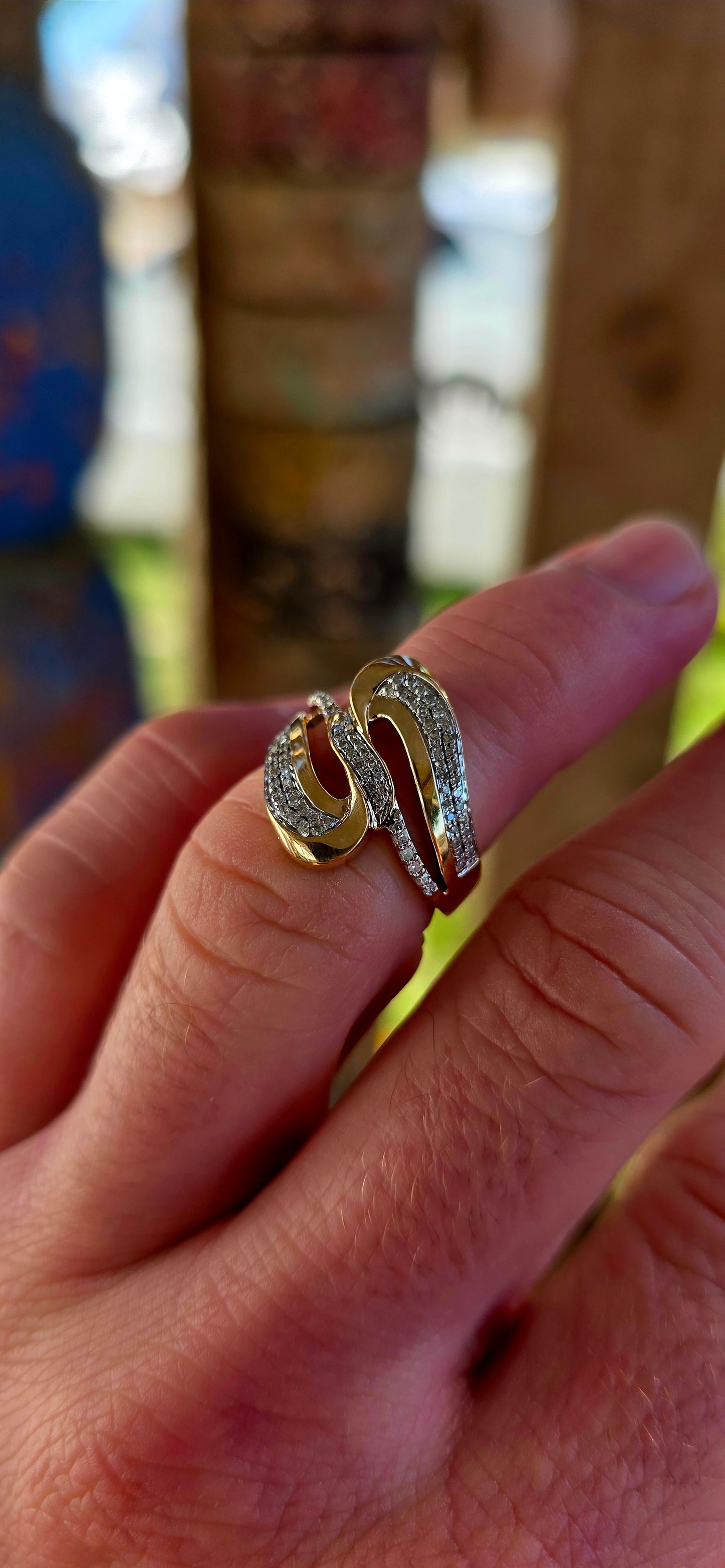 A striking modernist 9ct yellow gold dress ring, crafted in a bold passover / bypass (“toi et moi”) design, where two flowing forms curve gracefully around one another — symbolising two souls meeting and intertwining.