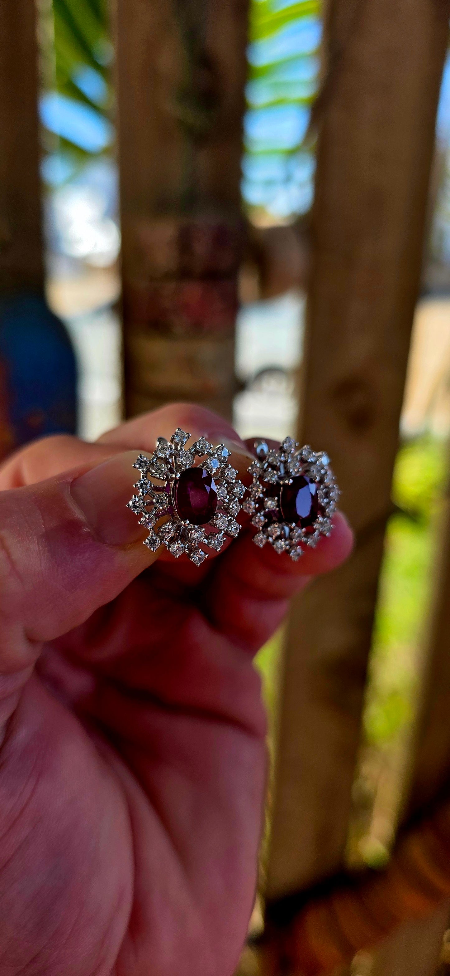 A striking pair of sterling silver starburst cluster earrings, designed to command attention from every angle. At the heart of each earring sits a rich oval-cut ruby, prong-set to let that deep, romantic red glow through beautifully.