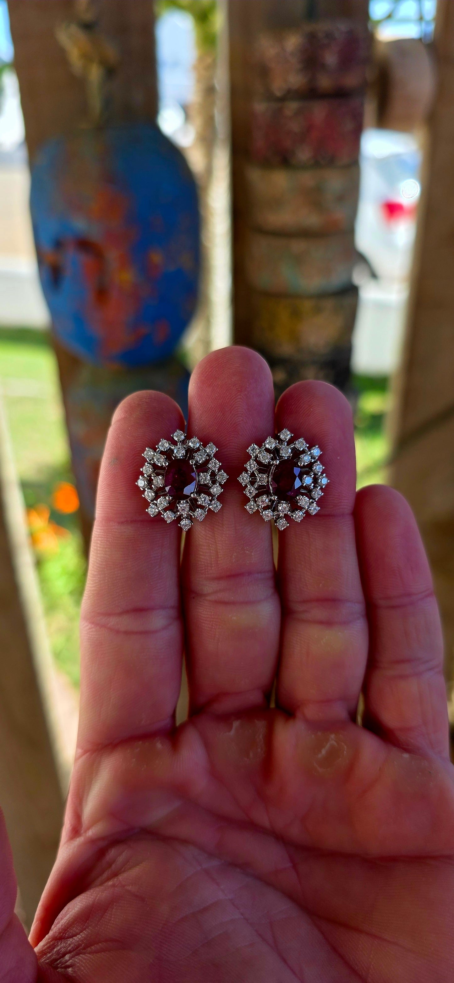A striking pair of sterling silver starburst cluster earrings, designed to command attention from every angle. At the heart of each earring sits a rich oval-cut ruby, prong-set to let that deep, romantic red glow through beautifully.