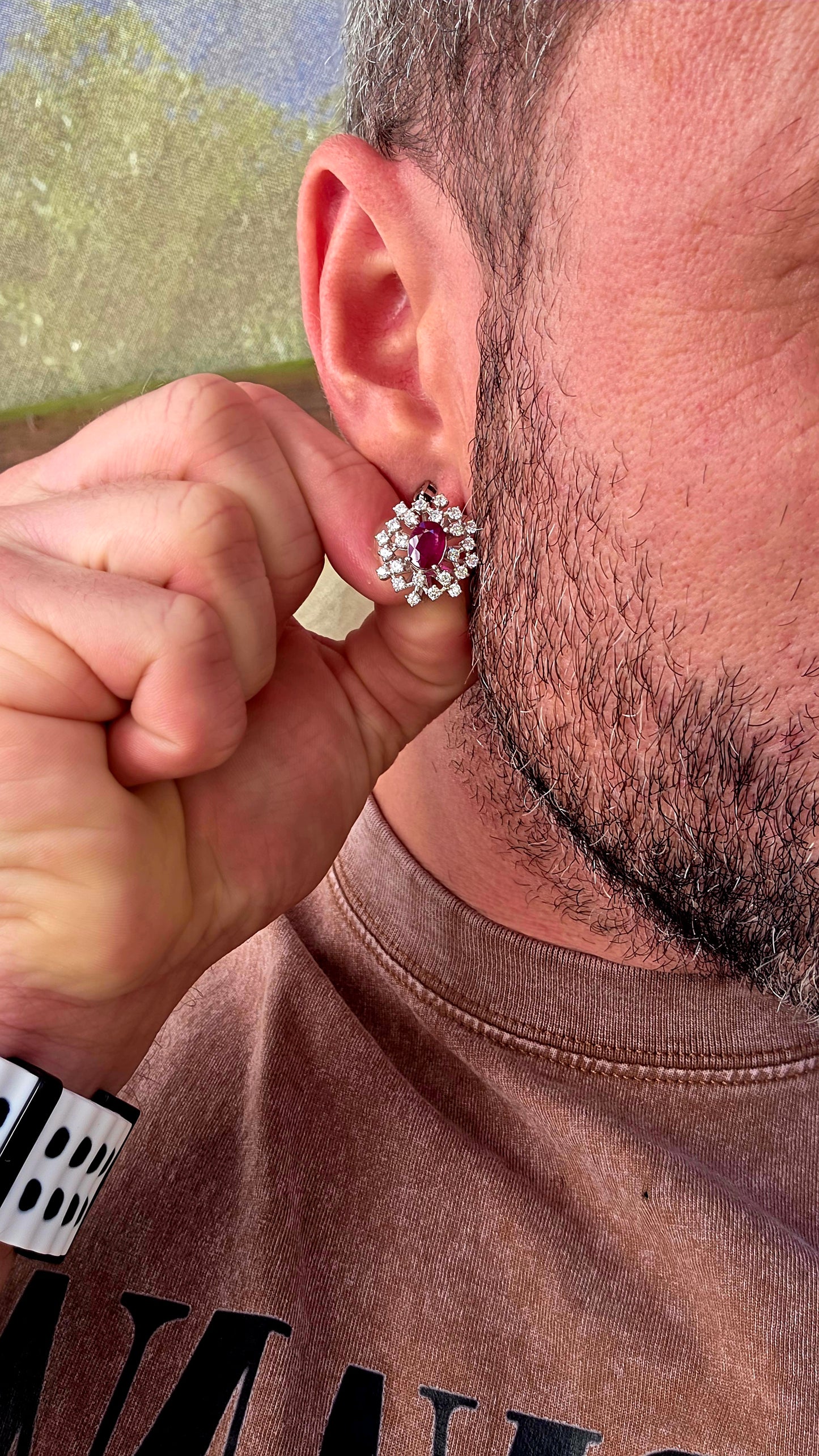 A striking pair of sterling silver starburst cluster earrings, designed to command attention from every angle. At the heart of each earring sits a rich oval-cut ruby, prong-set to let that deep, romantic red glow through beautifully.