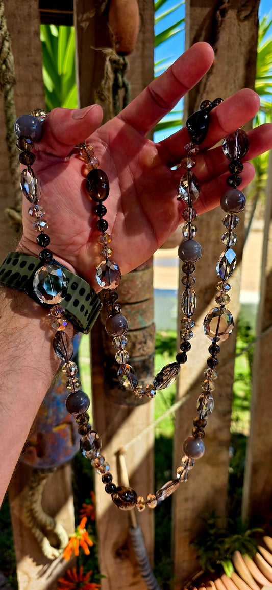 A chunky, extra-length, claspless statement necklace featuring a dazzling mix of Swarovski crystal beads and natural gemstones — bold, fluid, and absolutely dripping in sparkle.