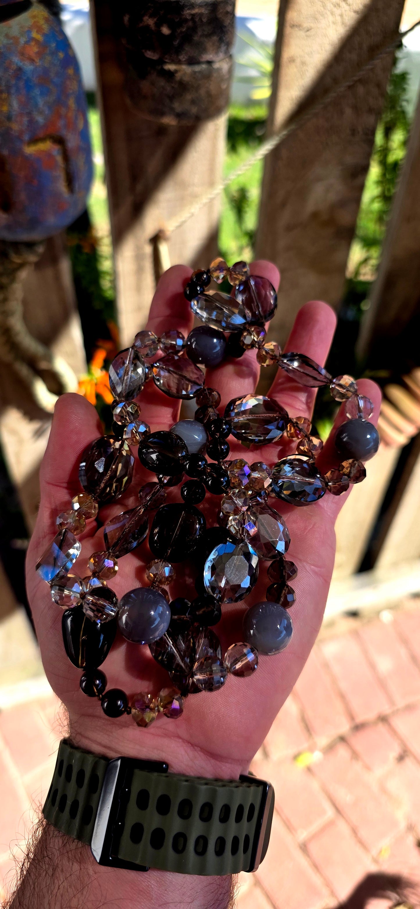 A chunky, extra-length, claspless statement necklace featuring a dazzling mix of Swarovski crystal beads and natural gemstones — bold, fluid, and absolutely dripping in sparkle.