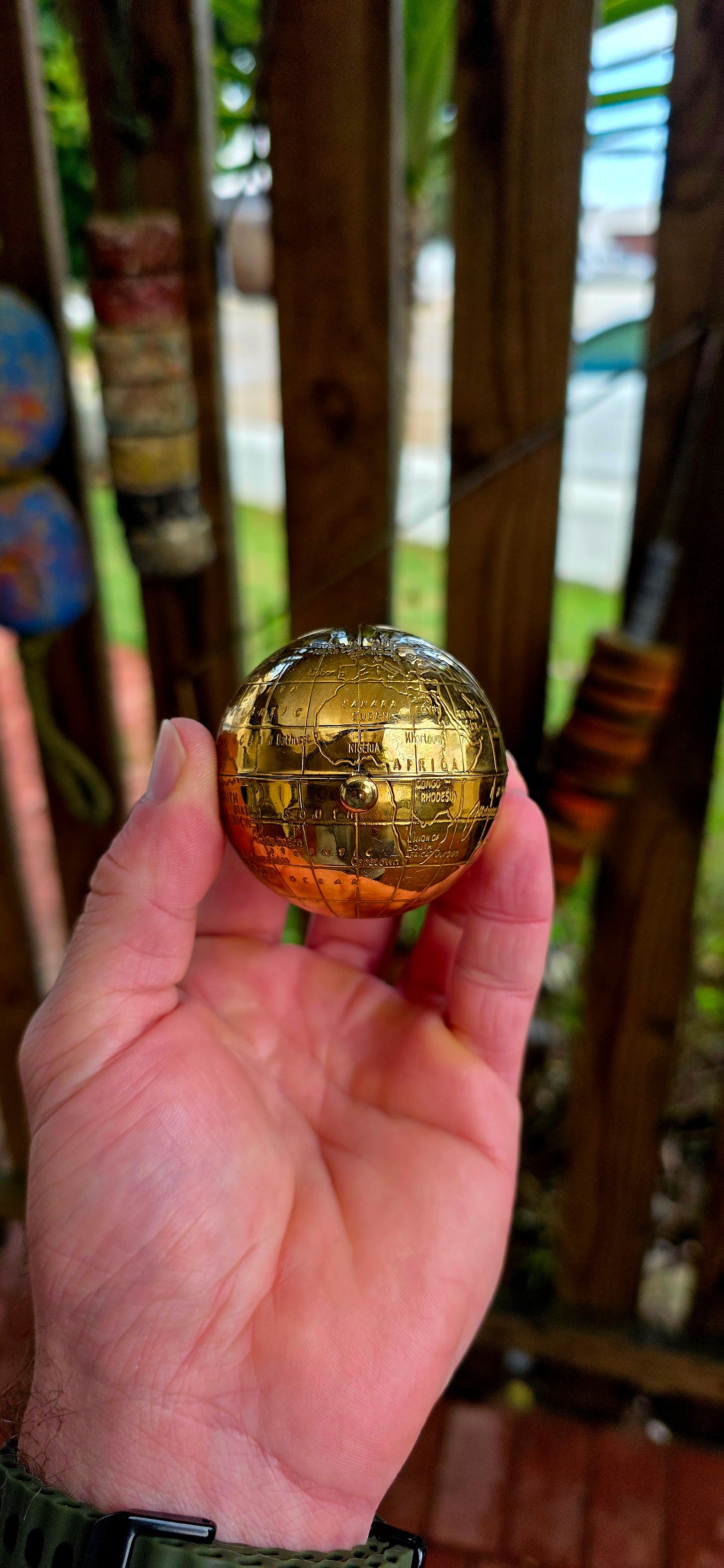 A wildly charming and highly sought-after mid-century novelty compact, beautifully crafted in warm golden brass — and shaped as a miniature world globe.