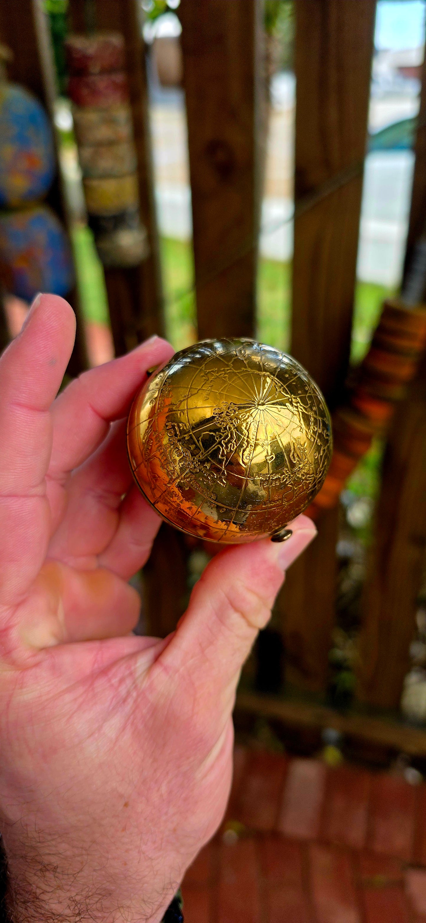 A wildly charming and highly sought-after mid-century novelty compact, beautifully crafted in warm golden brass — and shaped as a miniature world globe.