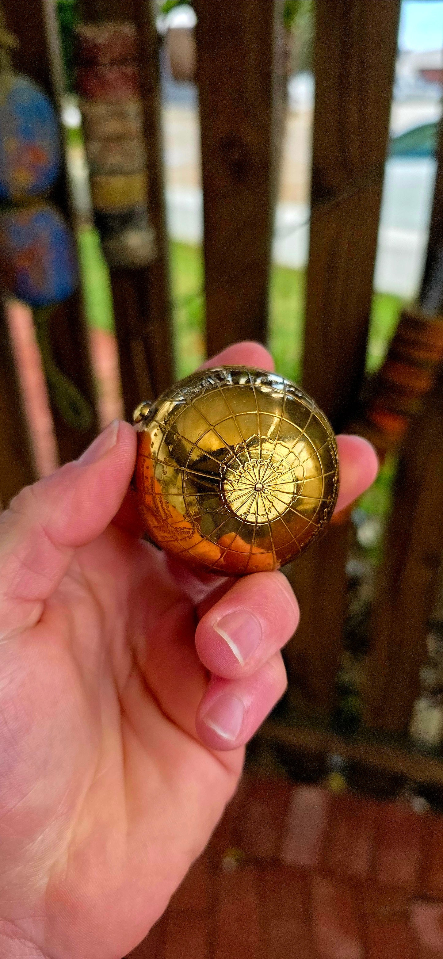 A wildly charming and highly sought-after mid-century novelty compact, beautifully crafted in warm golden brass — and shaped as a miniature world globe.