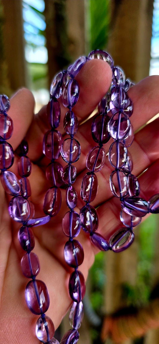 A striking extra-long strand of natural amethyst gemstone beads, glowing in those irresistible lavender-to-violet hues that shift beautifully in the light.