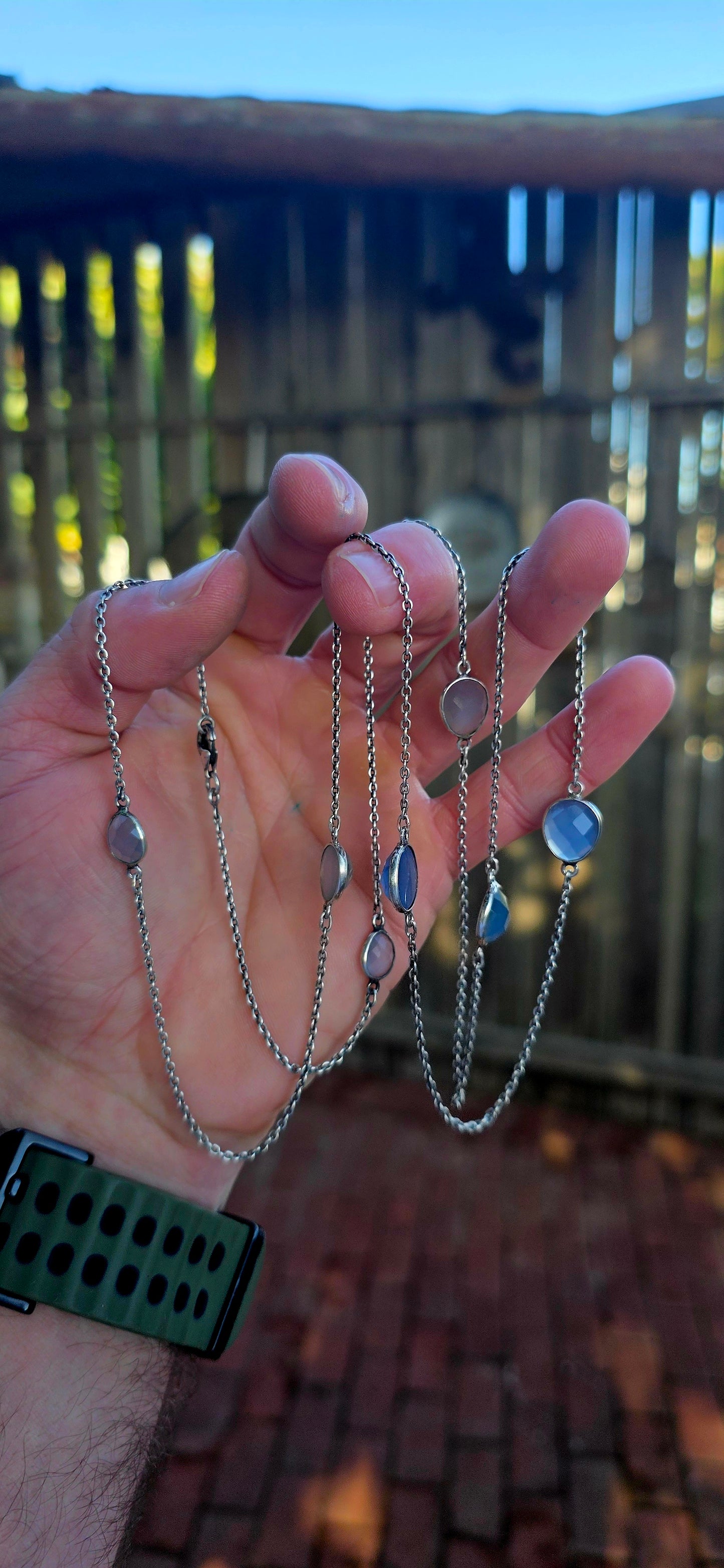 Extra-length sterling silver station-style necklace featuring a delicate scattering of faceted chalcedony gemstones gracefully suspended between fine sterling silver chain links.