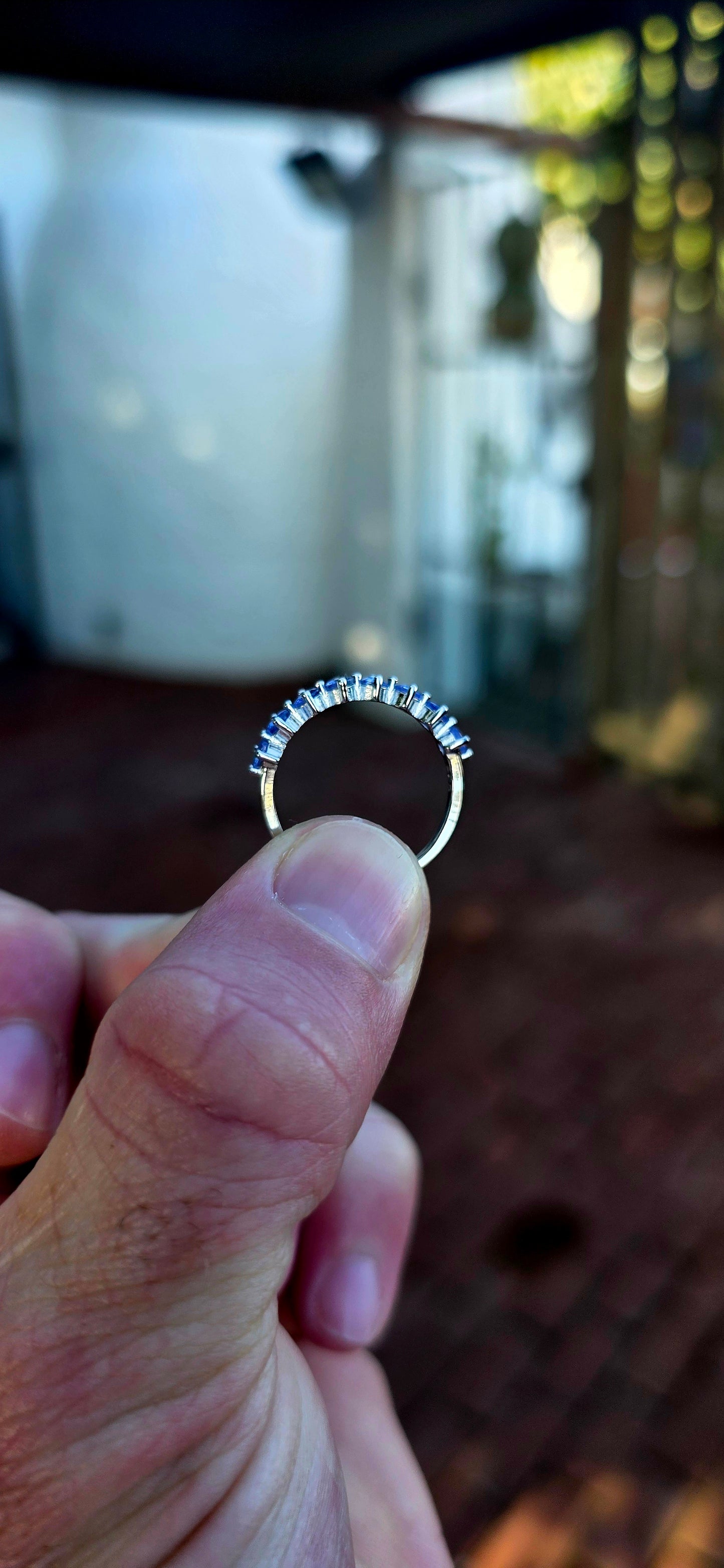Lovely sterling silver half-eternity stacking ring, prong set with 7 faceted round-cut tanzanite gemstones in the most dreamy soft violet-blue hues.