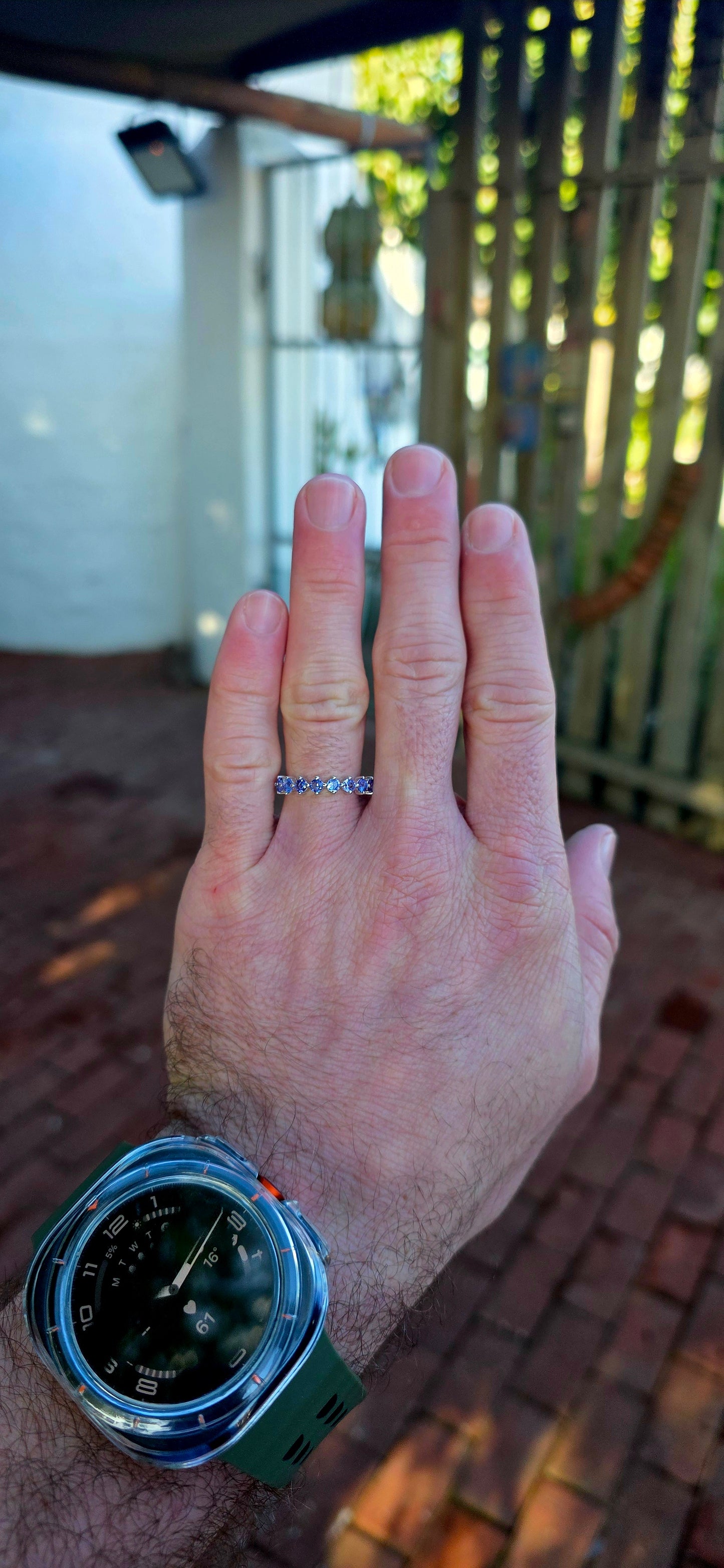 Lovely sterling silver half-eternity stacking ring, prong set with 7 faceted round-cut tanzanite gemstones in the most dreamy soft violet-blue hues.