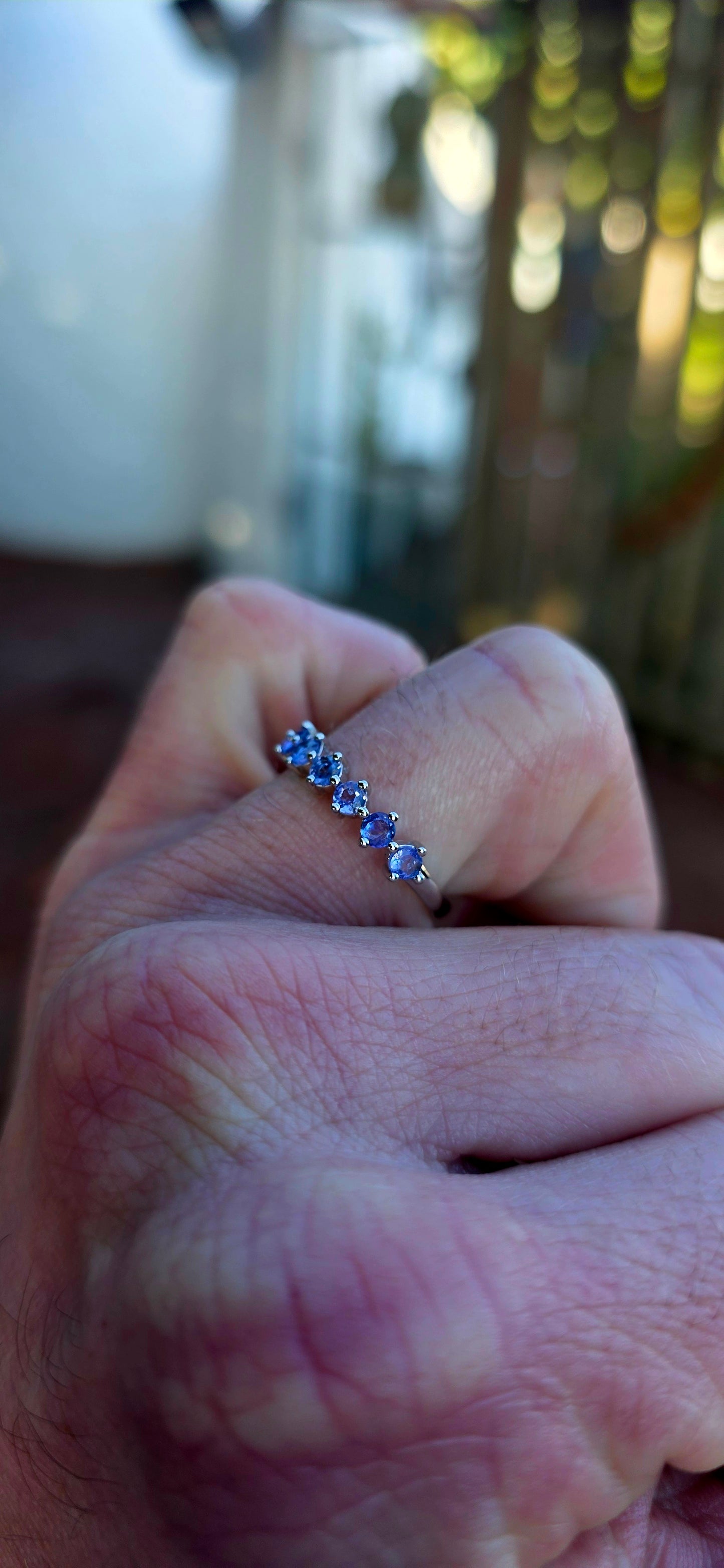 Lovely sterling silver half-eternity stacking ring, prong set with 7 faceted round-cut tanzanite gemstones in the most dreamy soft violet-blue hues.