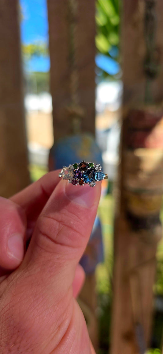 An enchanting sterling silver cluster ring finished in luminous rhodium plating, this marvelous piece feels like a tiny treasure chest of gemstones gathered from across the cosmos.